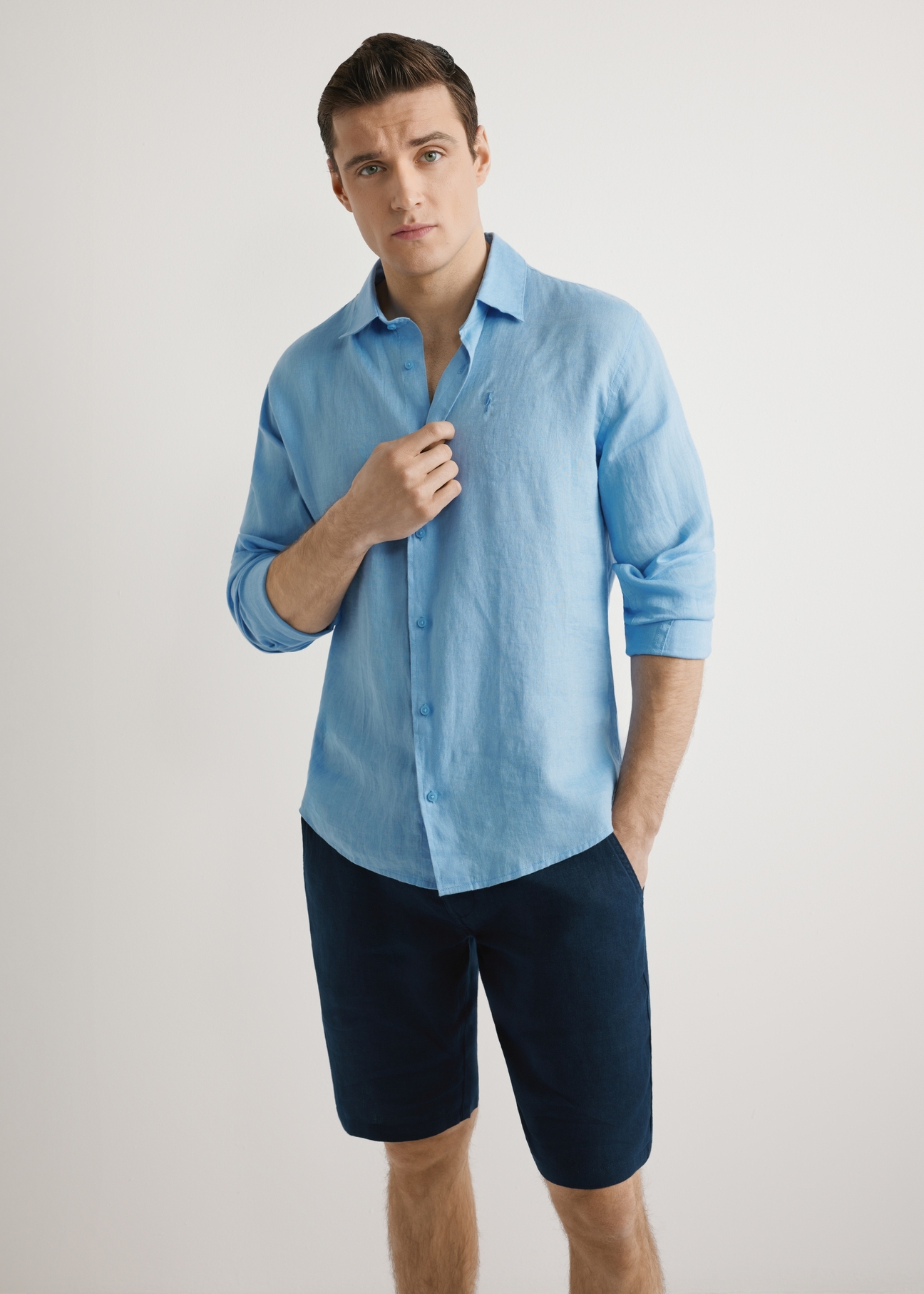 Blue men's linen shirt KOSMT-0321A-7B(W26), front product view, on model, against a light background. Half of the silhouette visible.