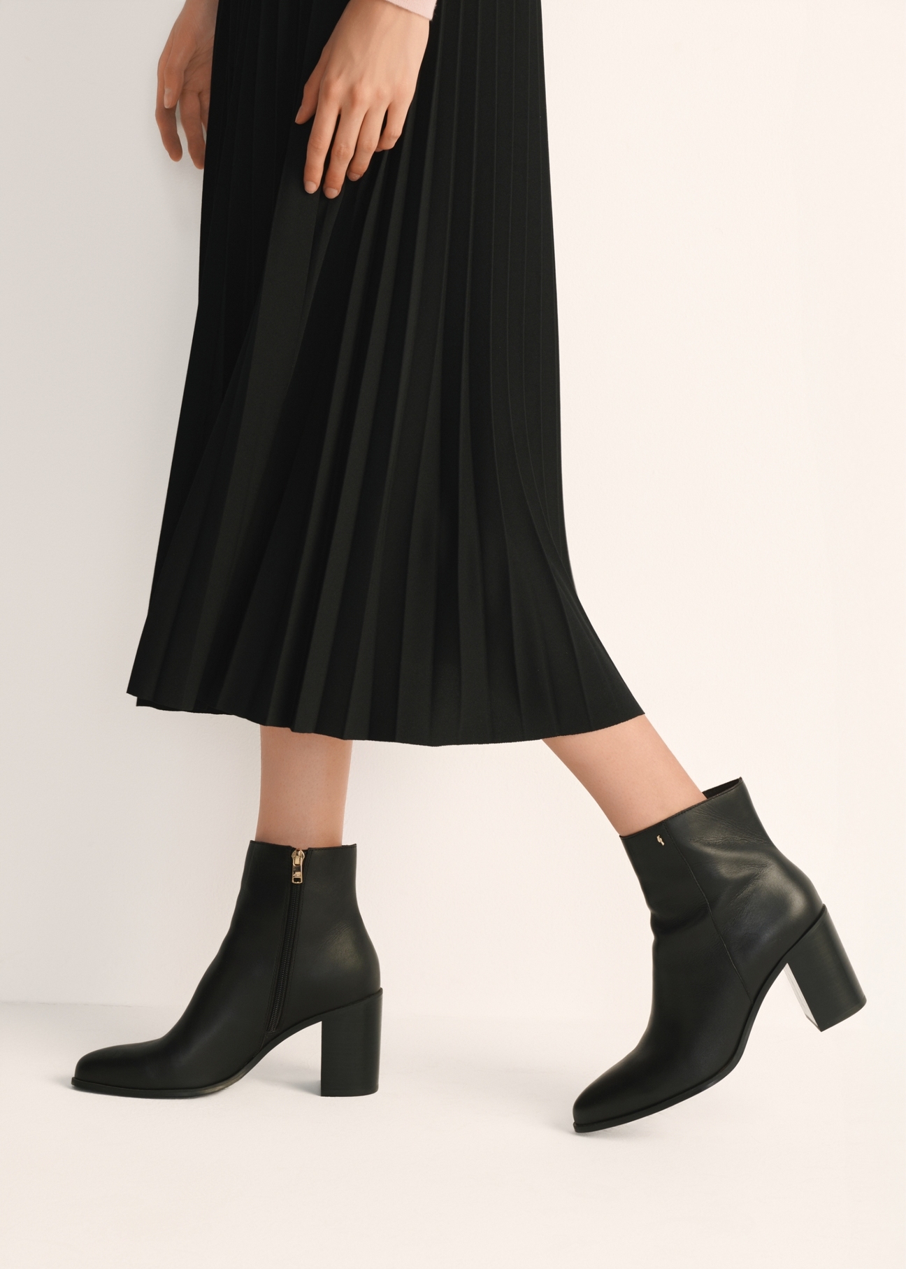 Black leather women's ankle boots BUTYD-1213-99(Z25), product view on model's feet against a light background.