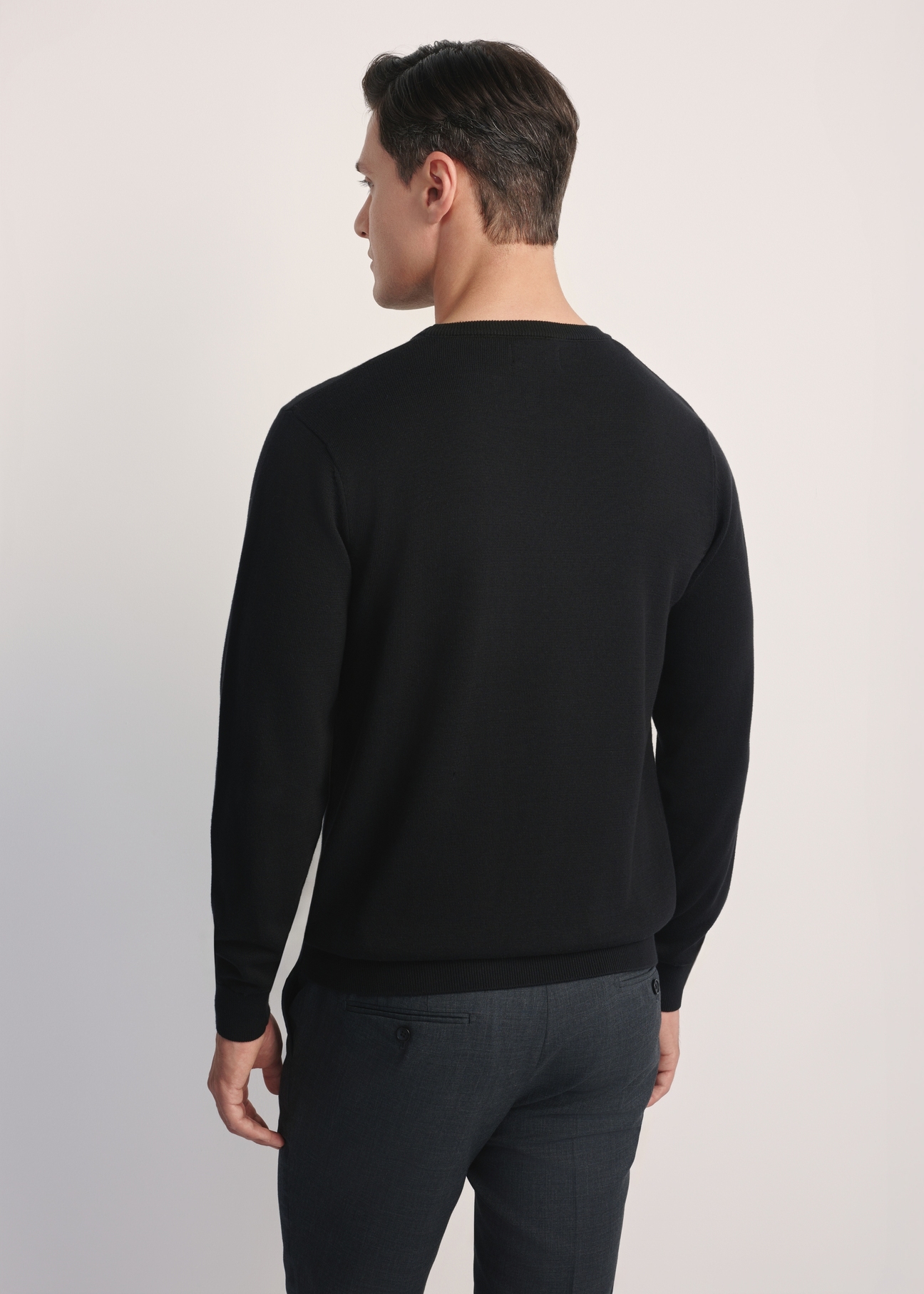 Black men's basic sweater SWEMT-0114A-99(Z24), view of the product from the back on the model, half of the silhouette visible.