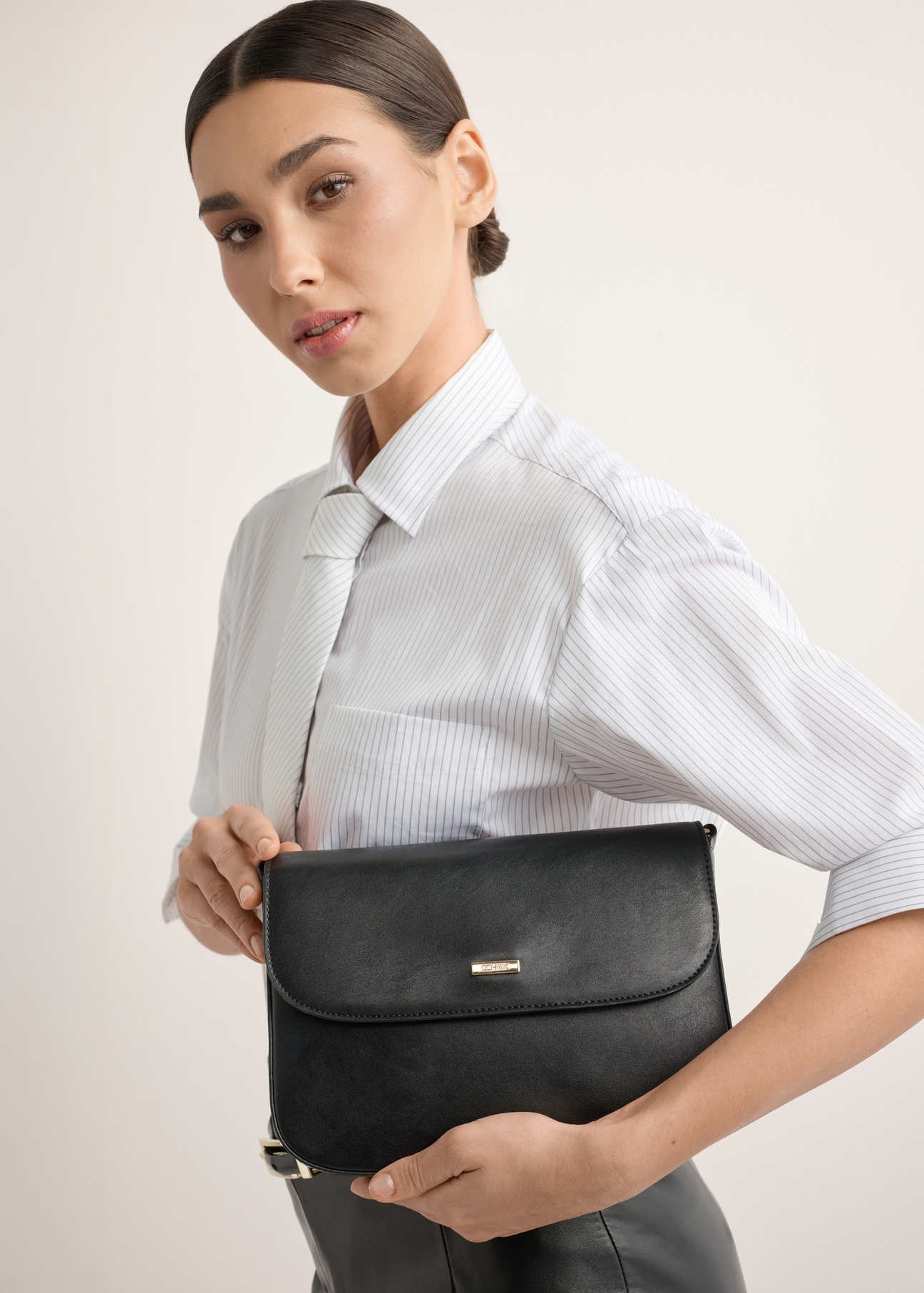 Black women's shoulder bag TOREC-1262-9F(Z26), front view of the product on a model. Half of the silhouette visible.