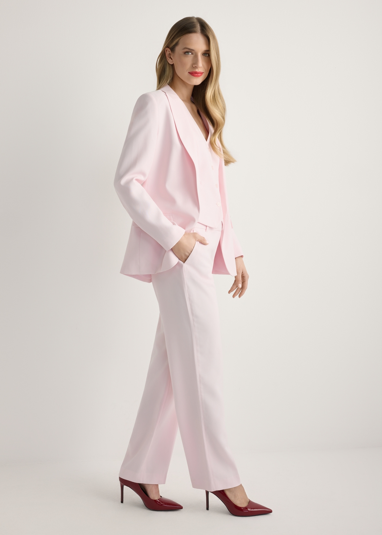 Women's pink blazer ZAKDT-0031A-5A(W26), side view of the product on the model. Full body visible.