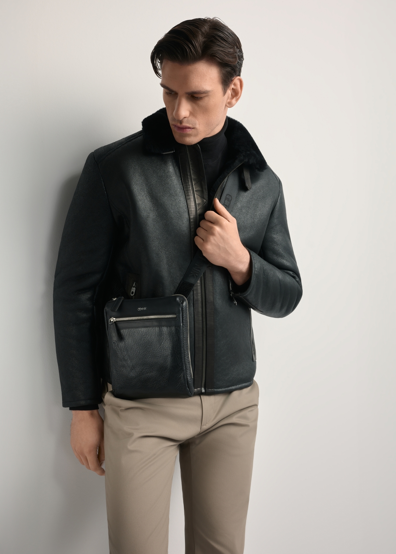 Men's leather messenger bag TORMS-0294A-99(Z25) - front view of the product, on a model, against a white background. Knee-length silhouette visible.