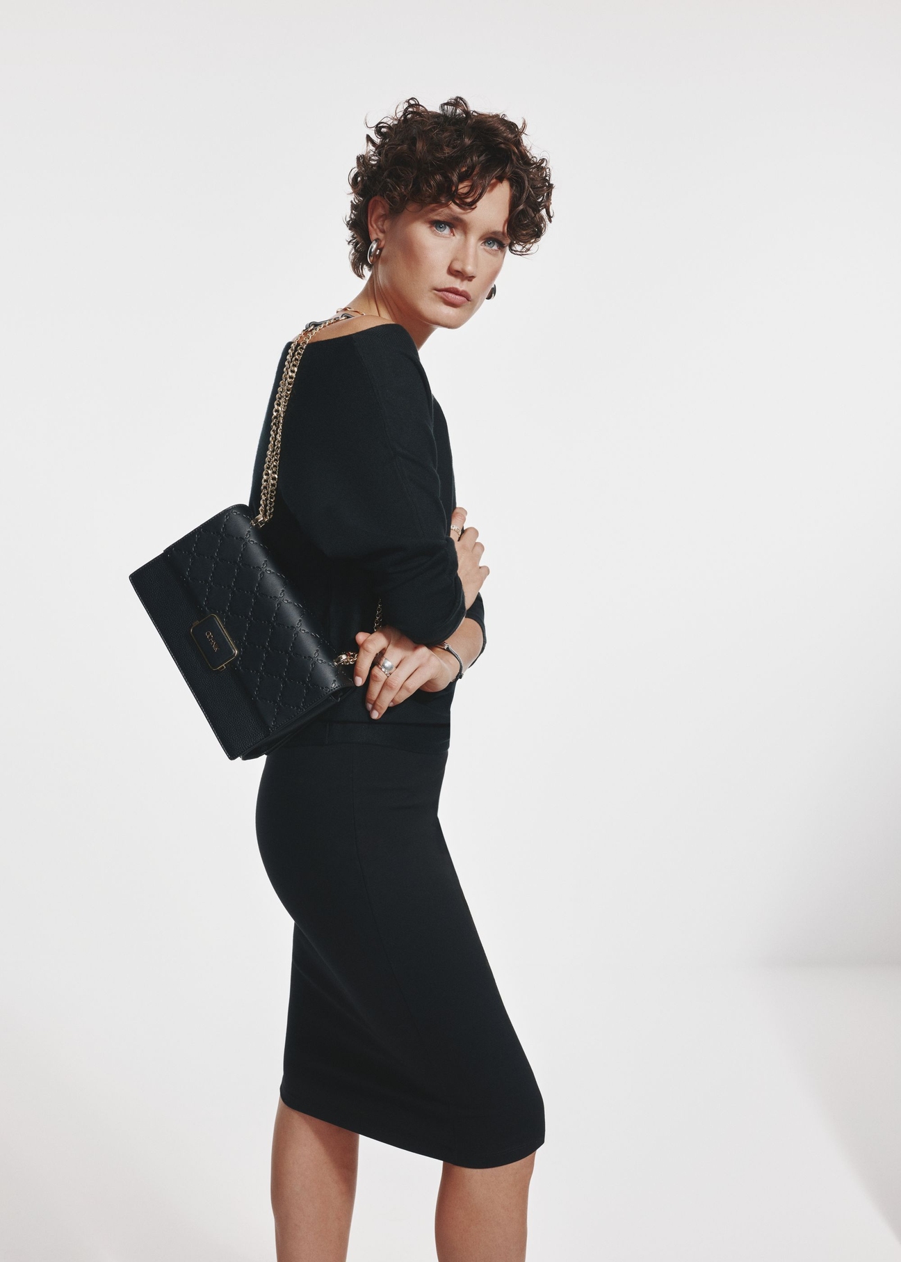 Black women's messenger bag TOREC-0984A-99(Z25) - view on a model on a white background. Visible silhouette.