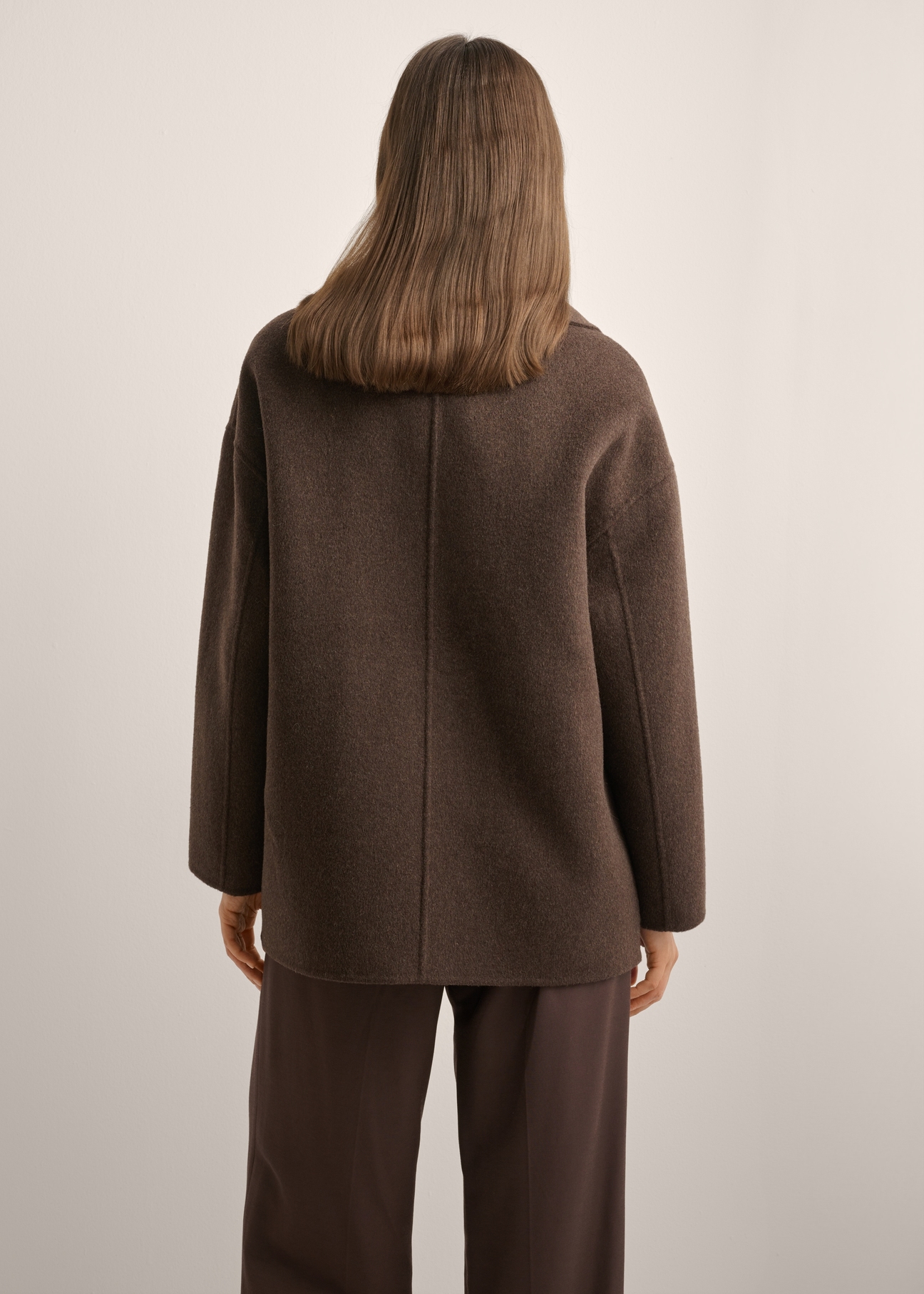 Women's long brown wool coat PLADT-0070-1K(Z26) - back view of the product, on a model, against a light background. Half of the silhouette visible.