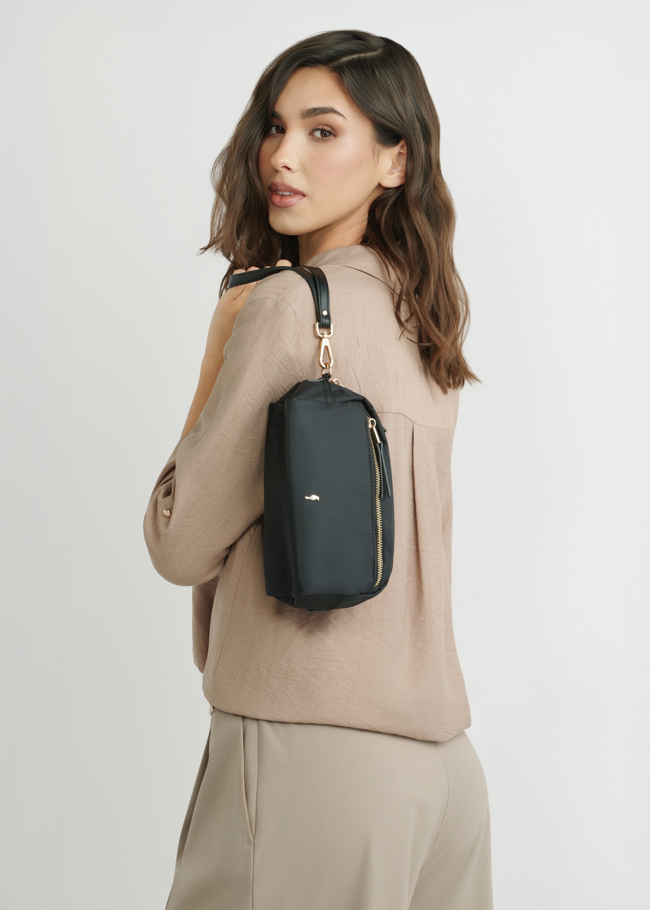 Black women's cosmetic bag TOREN-0347-99(W26), product view on a model's silhouette, on a light background.