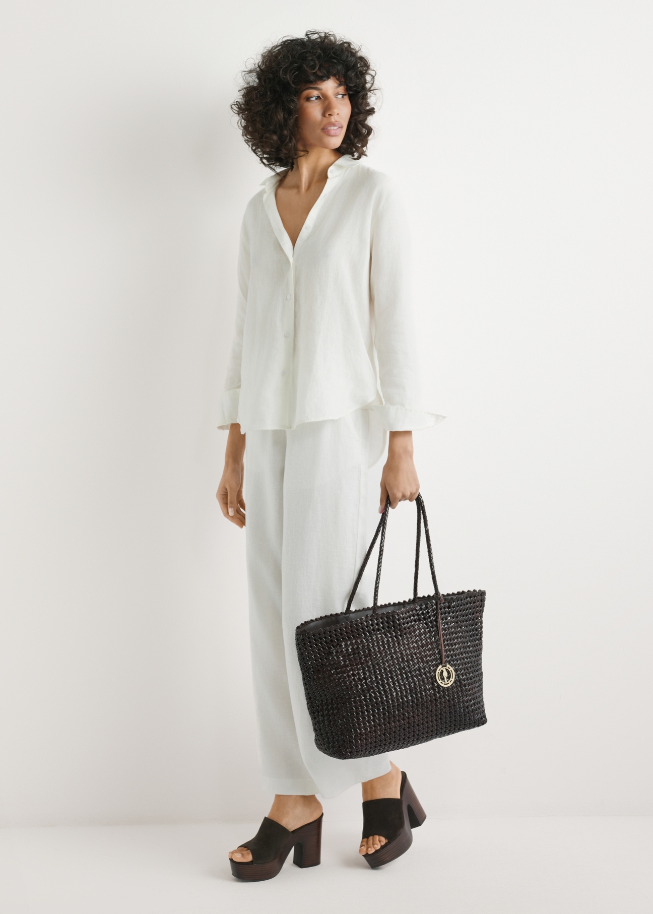 Brown leather woven handbag TORES-1300-1H(W26) - front view of the product, held in the model's hand, against a light background.