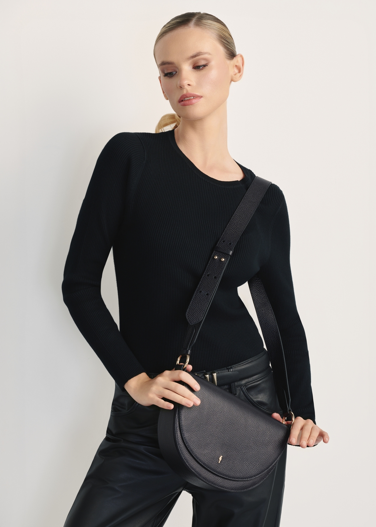 Leather semicircular women's handbag TORES-1190-99(Z25), product visible from the front on the model, on a white background. Half of the silhouette visible.