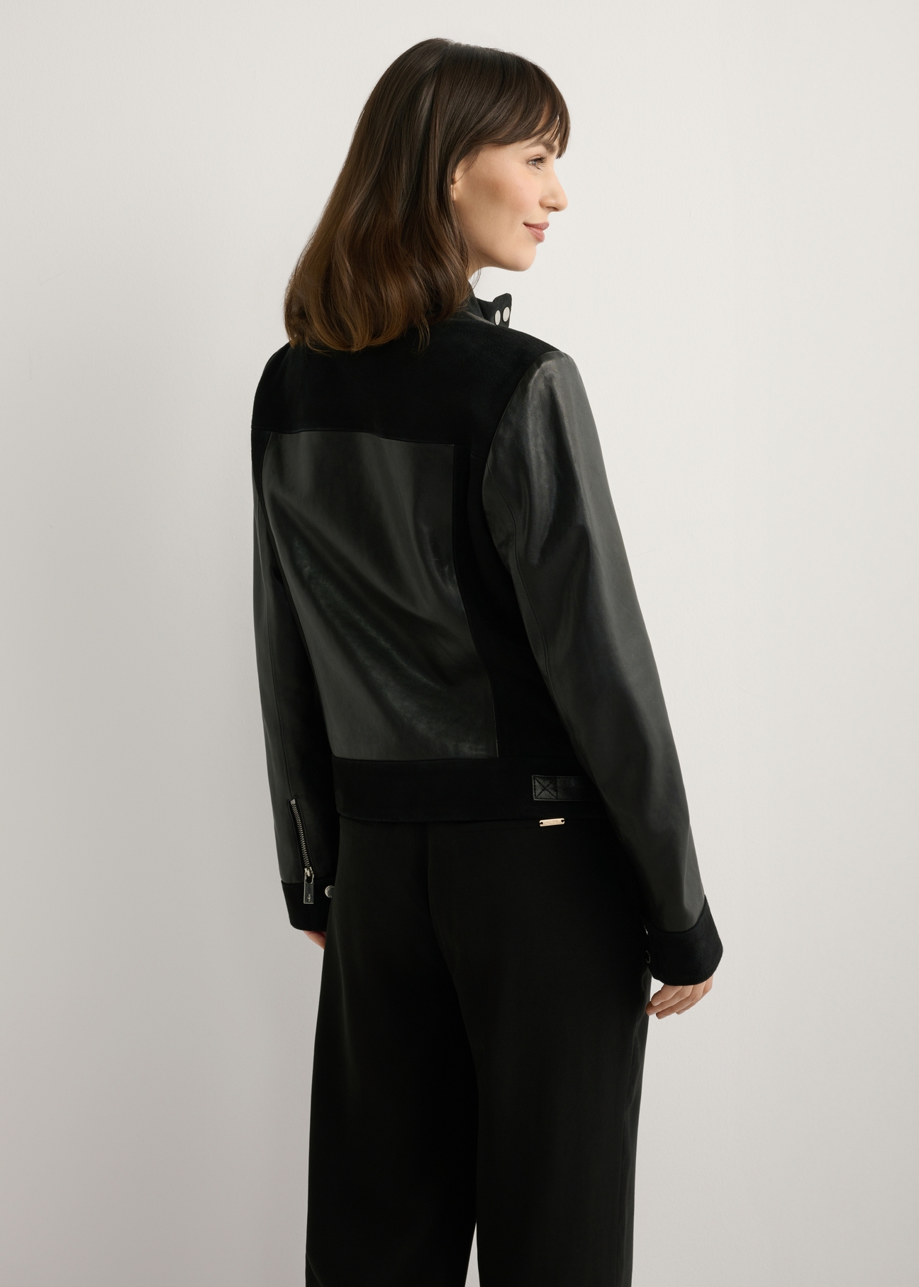 Women's black leather jacket KURDS-0587-99(W26), back view of the product on the model. Half of the silhouette visible.