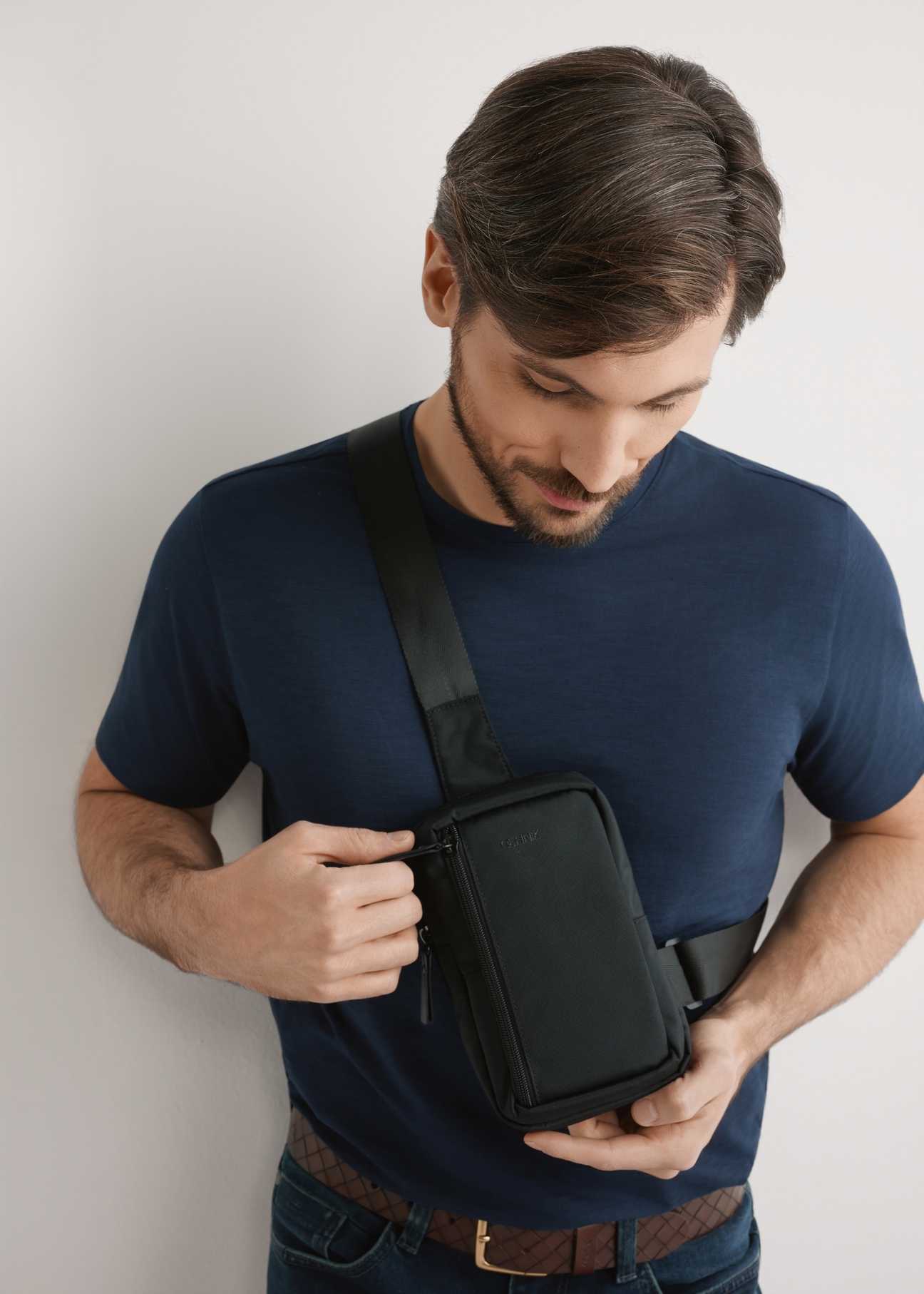 Black small men's bag TORMN-0390-99(W26), product view on the model's silhouette, on a light background.