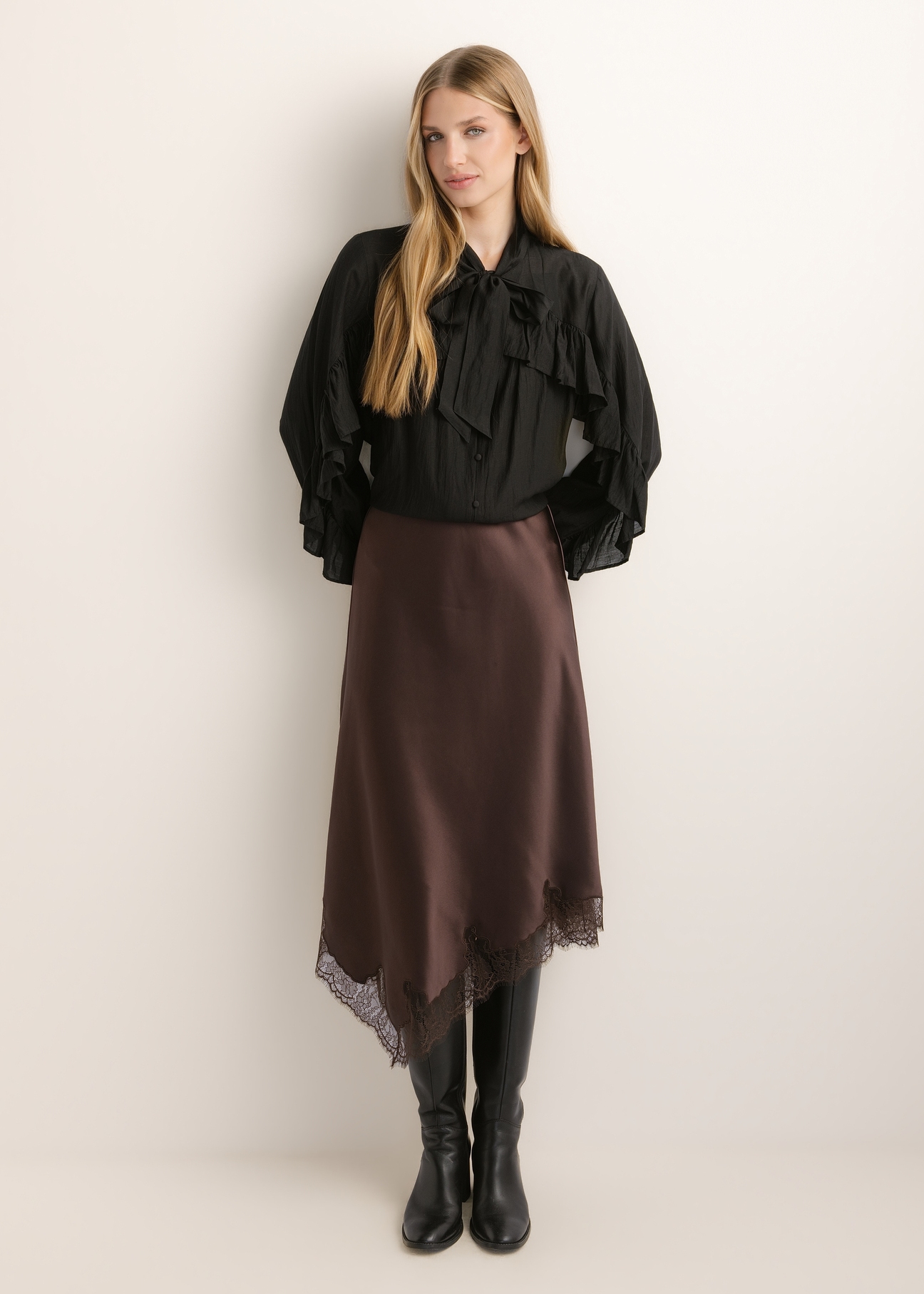 Dark brown asymmetrical women's skirt SPCDT-0135-1I(Z26), front view of the product on the model. Full body visible.