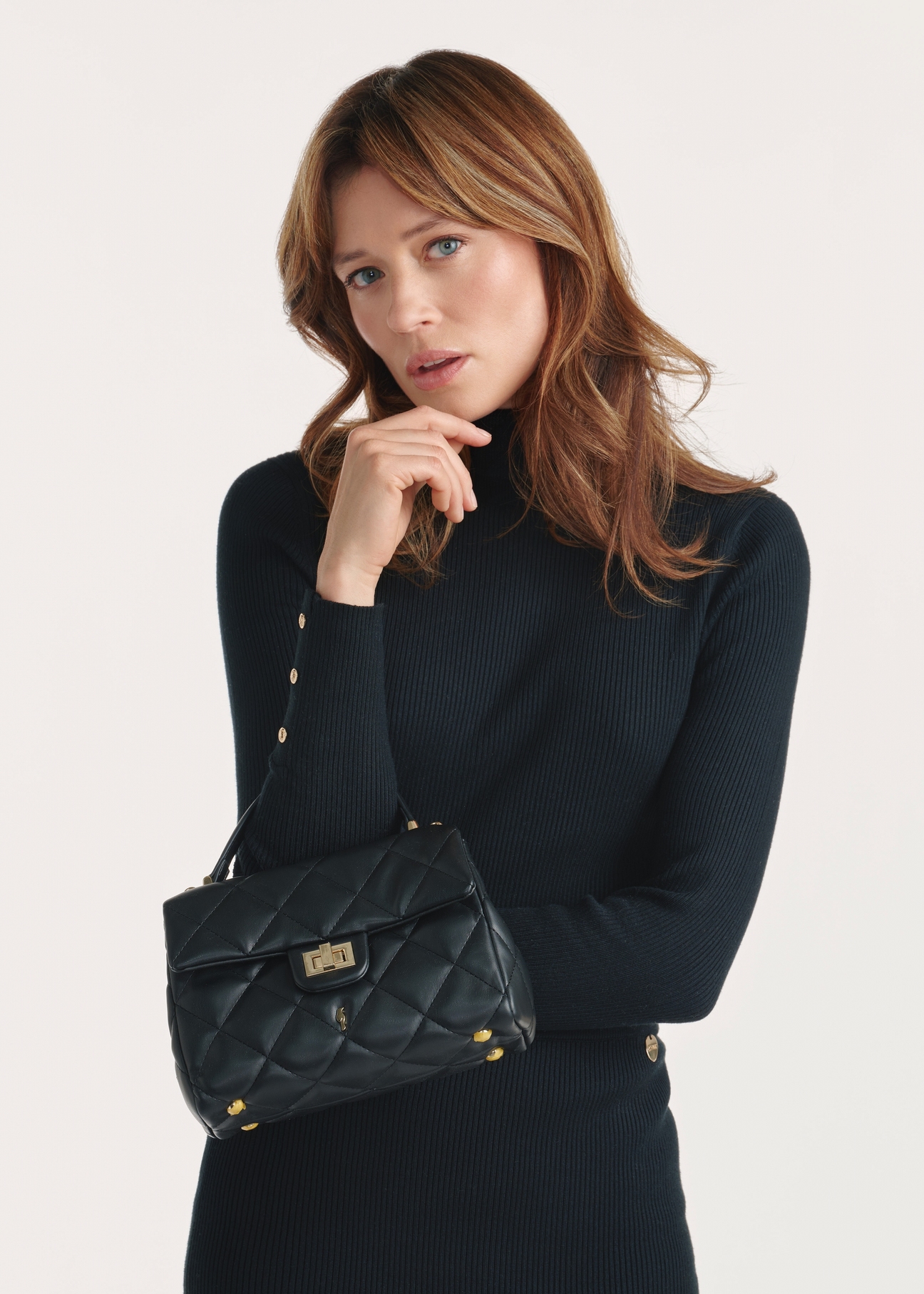 Black small quilted women's handbag TOREC-1092-99(Z25), product view on a model, half of the silhouette visible.