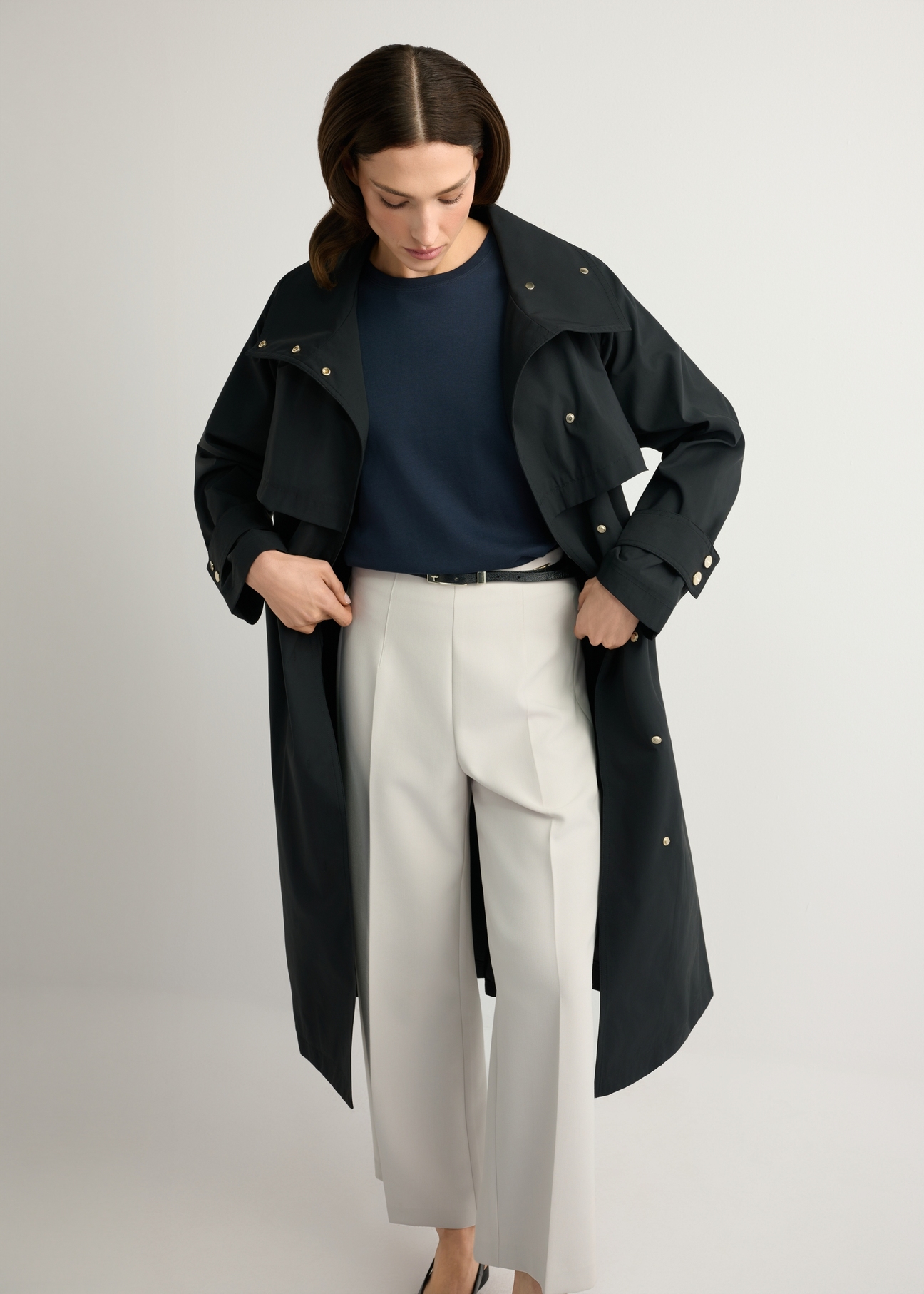 Women's black long coat KURDT-0653-99(W26), front view of the product on the model. Half of the silhouette visible.