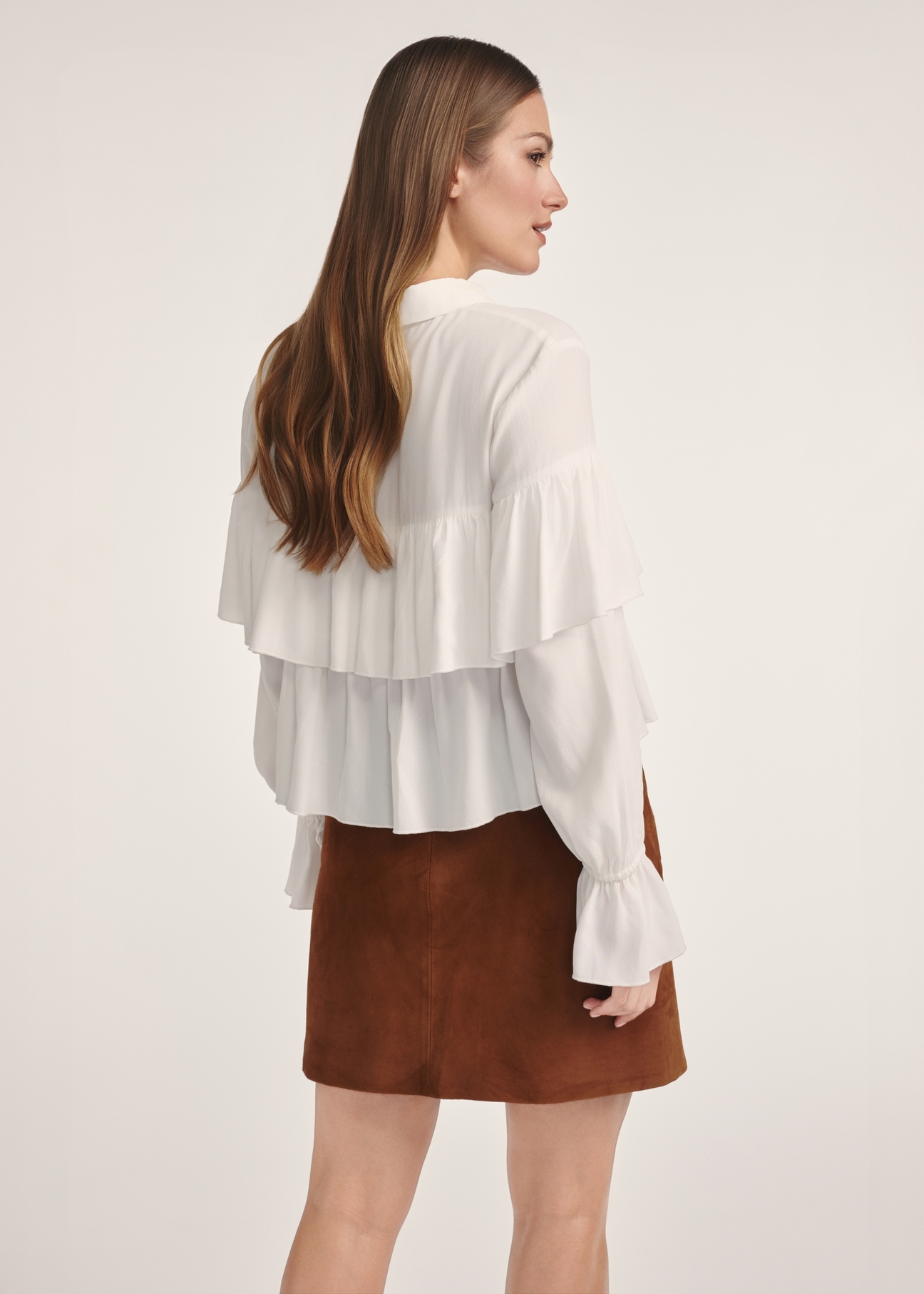 Women's white blouse with frills BLUDT-0198-12(Z25), product view from the back on the model. Half of the silhouette visible.