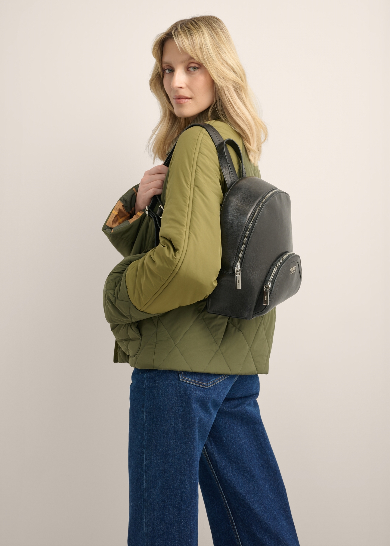 TORES-1378-99(Z26) women's black leather backpack, diagonal view of the product on the model. Half of the silhouette visible.