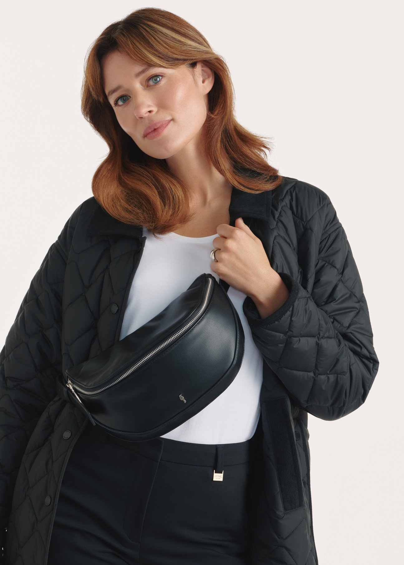 Black women's handbag TOREC-1050-99(Z25), front view of the product on the model, half of the silhouette visible.