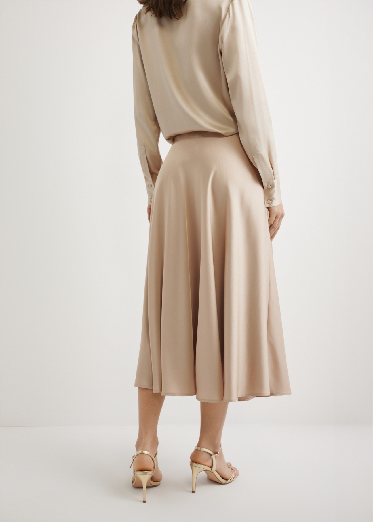 Long beige midi skirt SPCDT-0131-1B(W26), back view of the product on the model. Half of the silhouette visible.