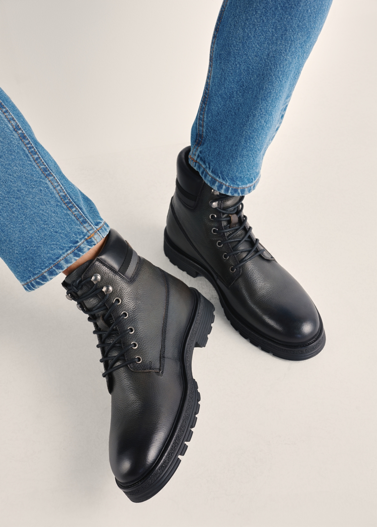 Black men's leather ankle boots BUTYM-0504-99(Z25), product view on model's feet against a light background.