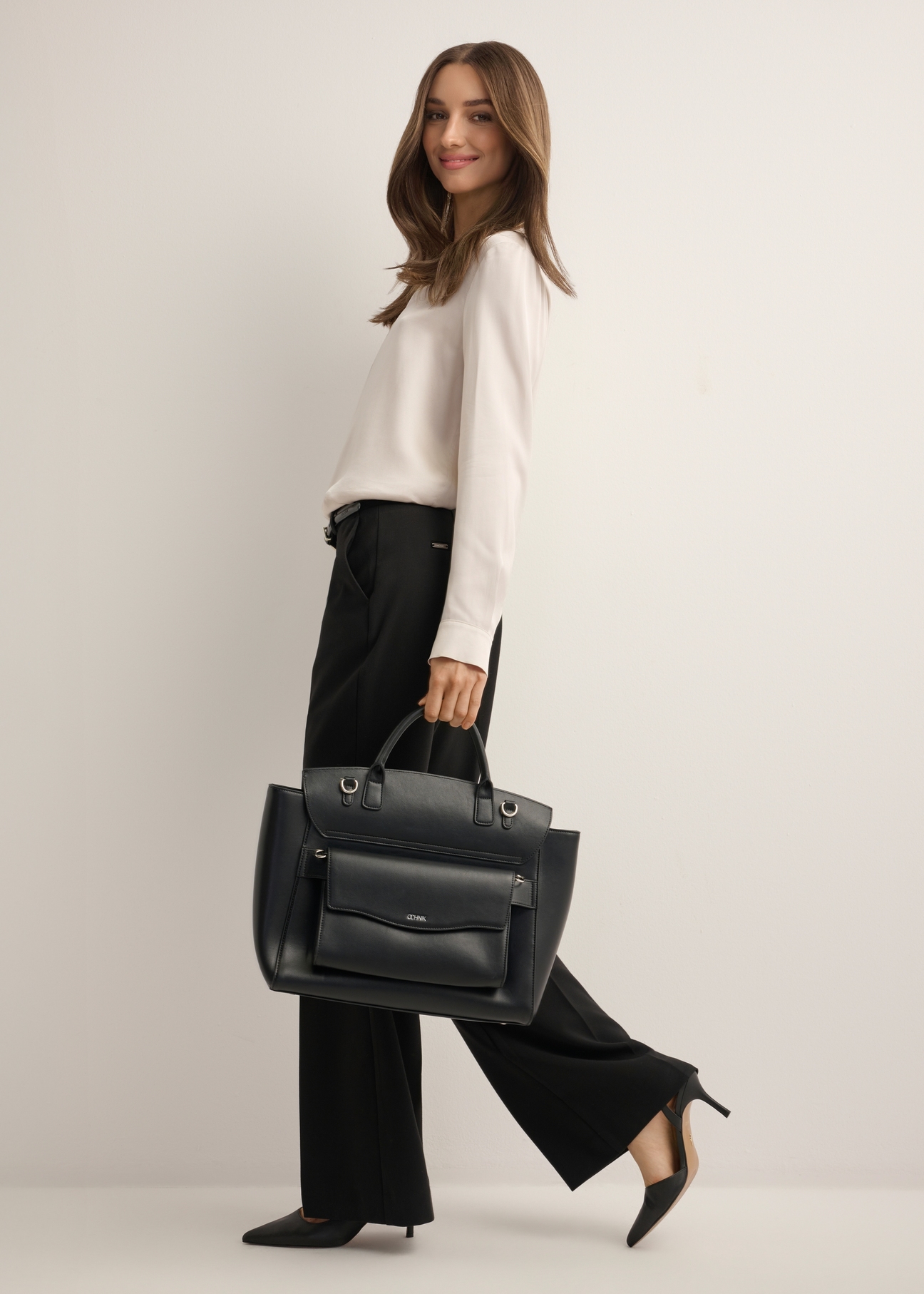 Black women's business briefcase TOREC-1280-99(Z26), front view of the product on a model. Full body view.