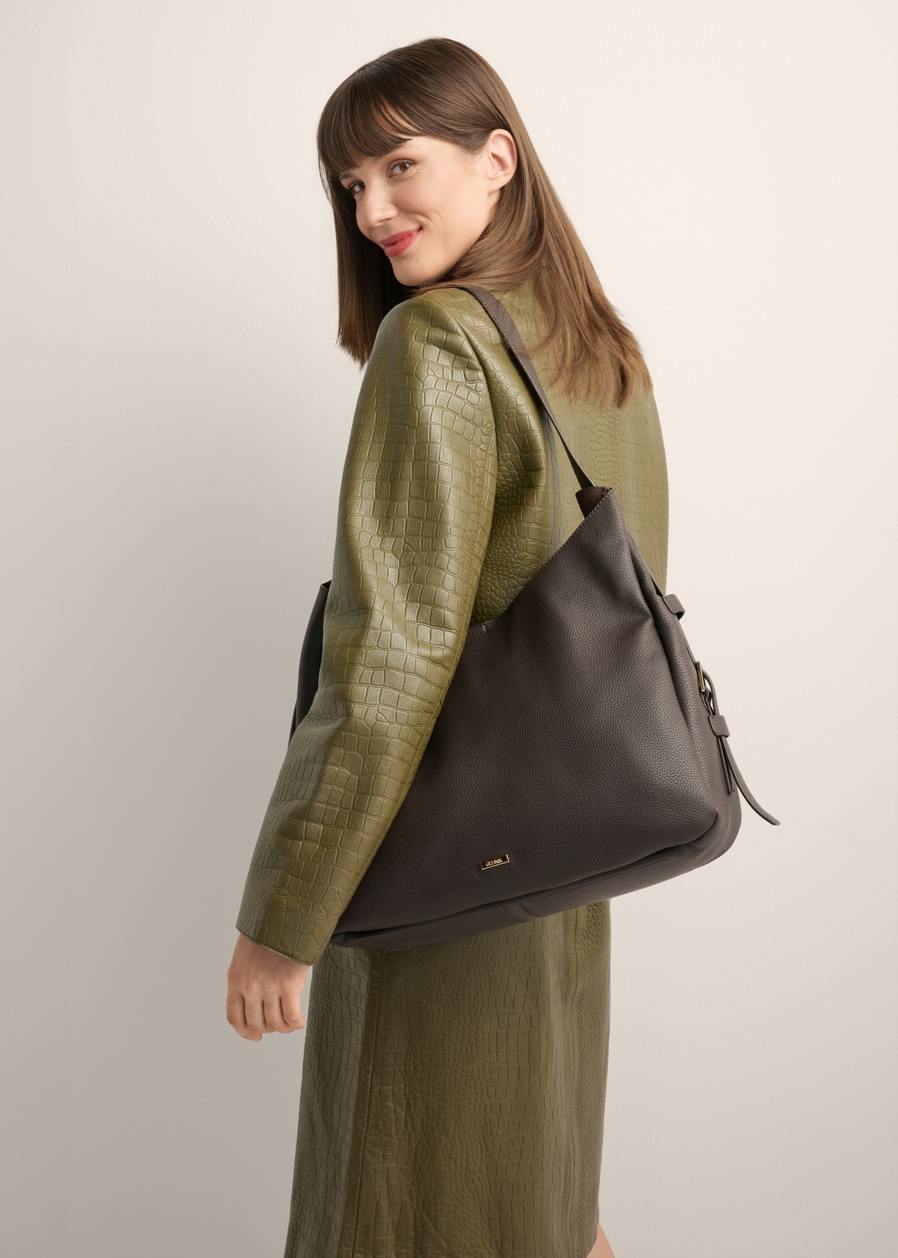 Brown shoulder shopper bag TOREC-1366-1I(Z26), product view on model's shoulder. Half of silhouette visible.