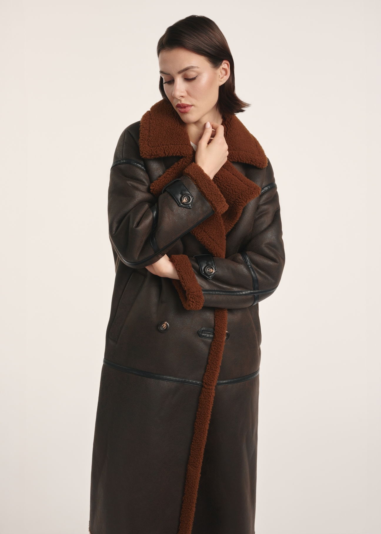 Long brown women's sheepskin coat KOZDP-0014-90(Z25) - front view of the product on a model on a white background. Visible silhouette to the knee.