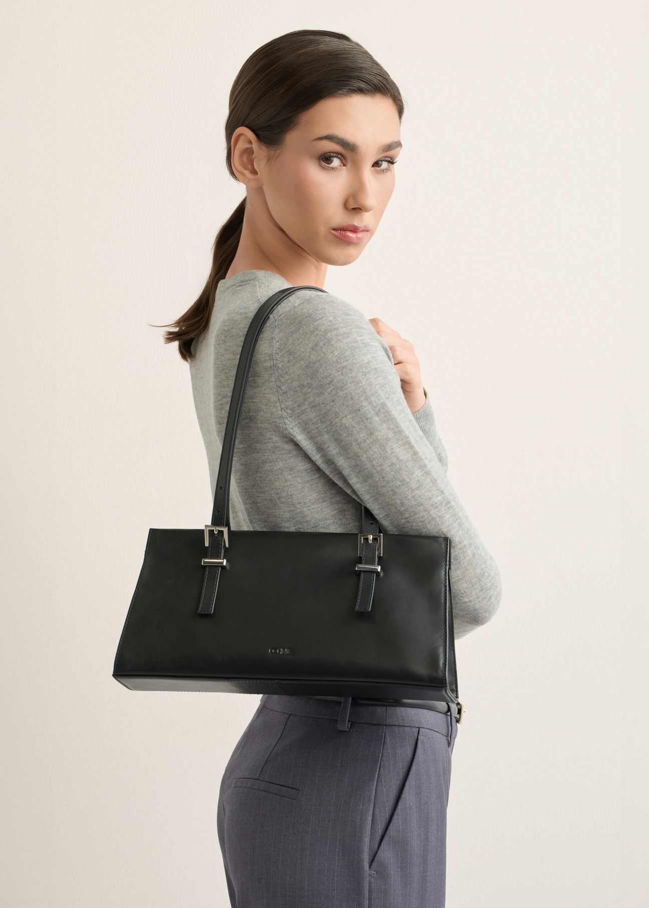 Women's black leather shoulder bag TORES-1429-99(Z26), product view on model's shoulder. Half of silhouette visible.