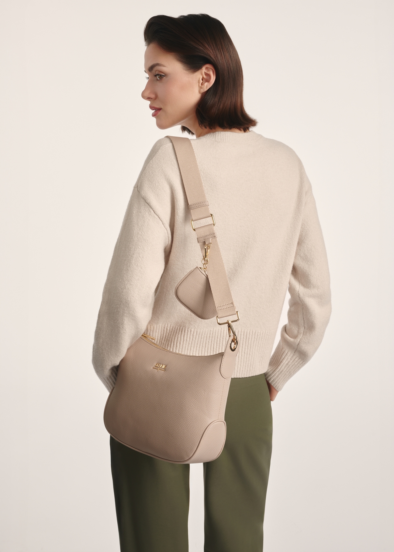 Beige women's hobo-style handbag TOREC-0829 A-80(Z 25), product view on model's shoulder. Half of silhouette visible.