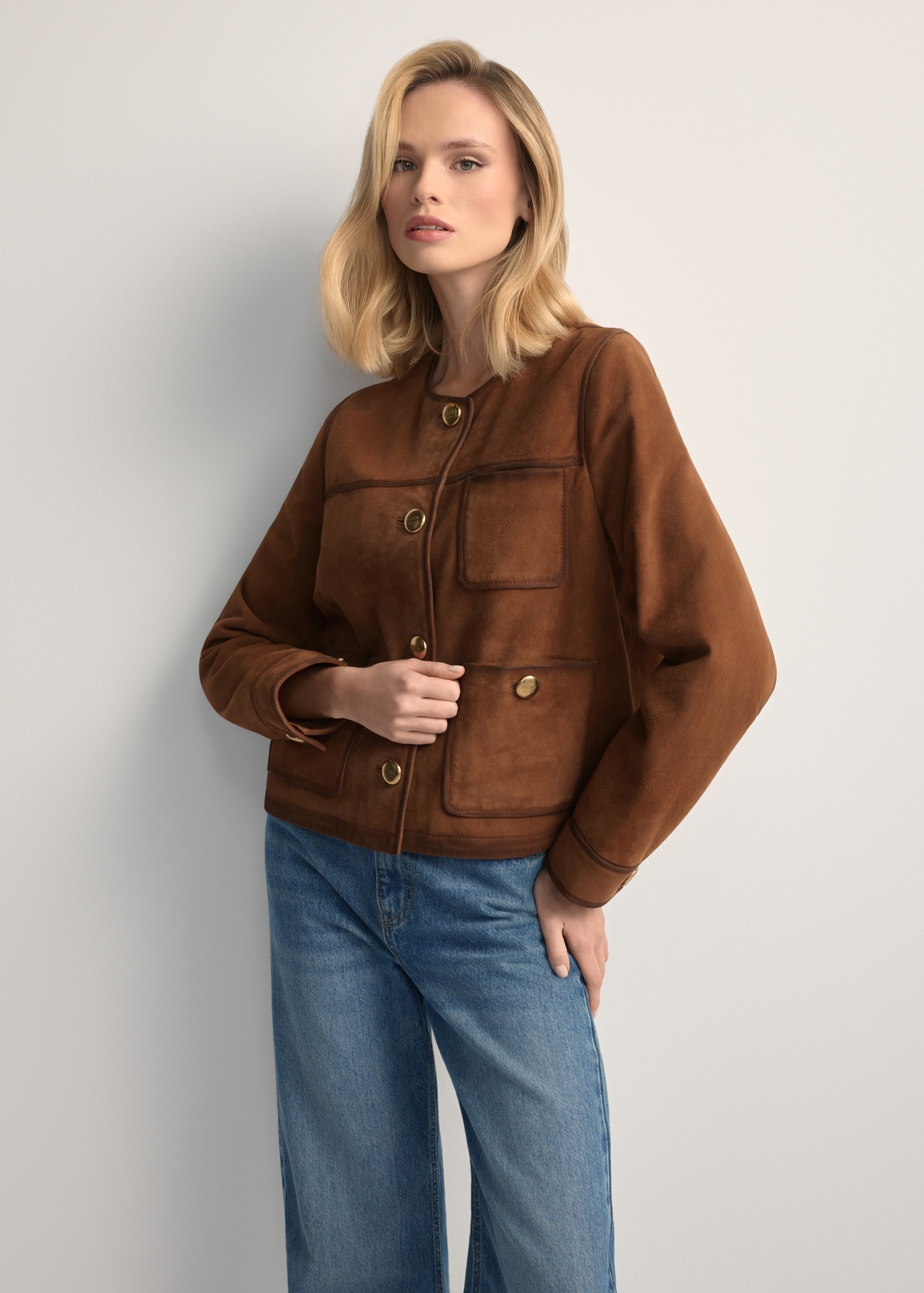Women's cognac suede jacket KURDS-0584-1F(W26) - front view of the product, on a model, against a light background. Knee-length silhouette visible.