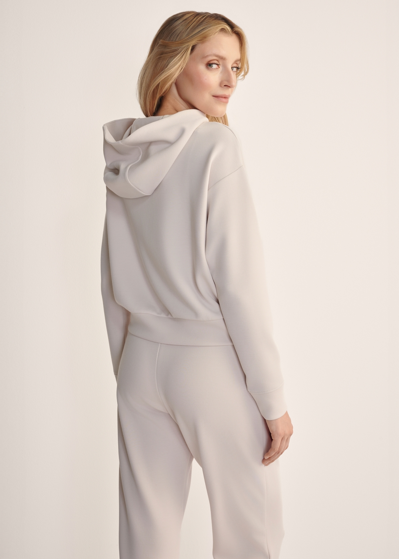 Light beige women's hooded sweatshirt BLZDT-0118-80(Z25), back view of the product on the model. Half of the silhouette visible.