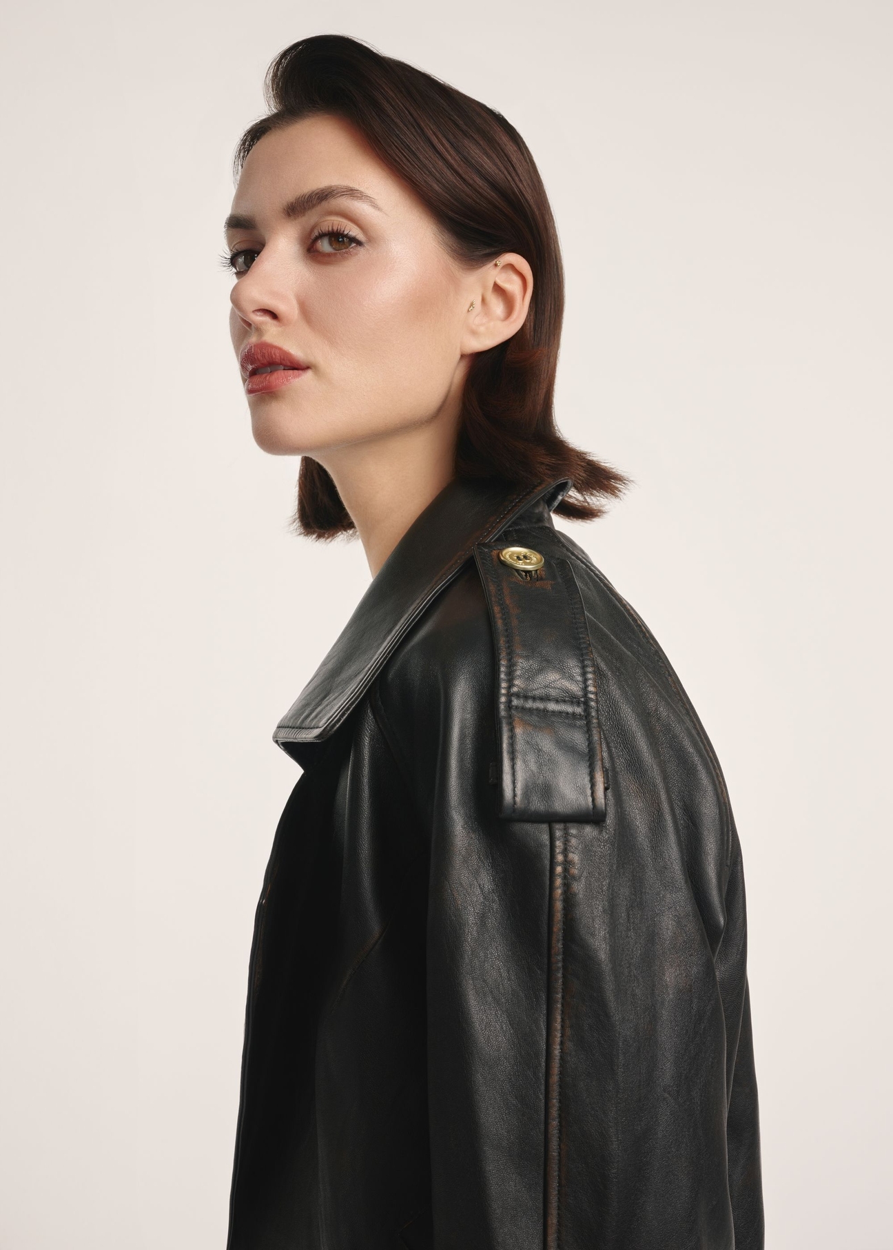 Brown oversize women's leather jacket KURDS-0553-2737(Z25), product visible diagonally on the model, half of the silhouette visible.