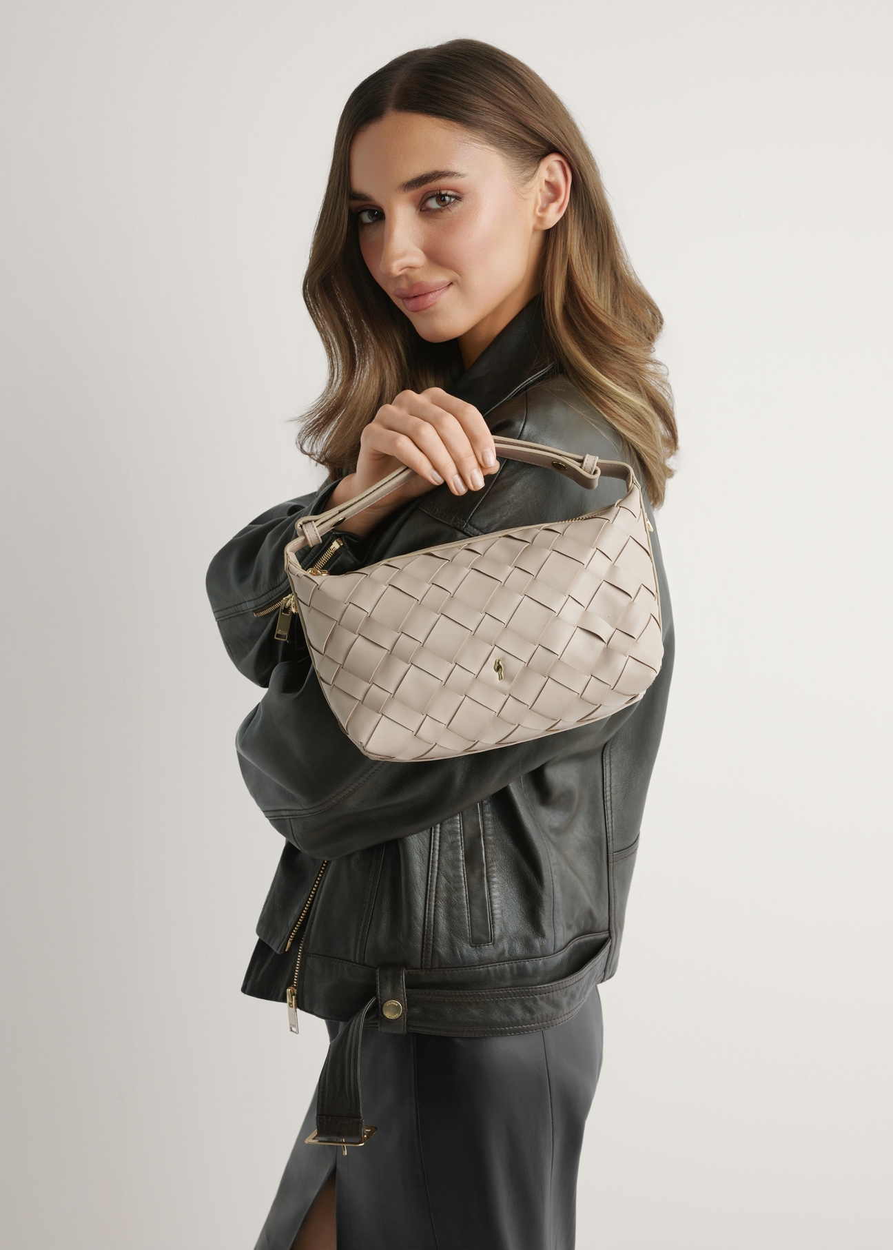 Beige women's handbag with braid TOREC-1169-1A(W26), product view in model's hand. Half of silhouette visible.