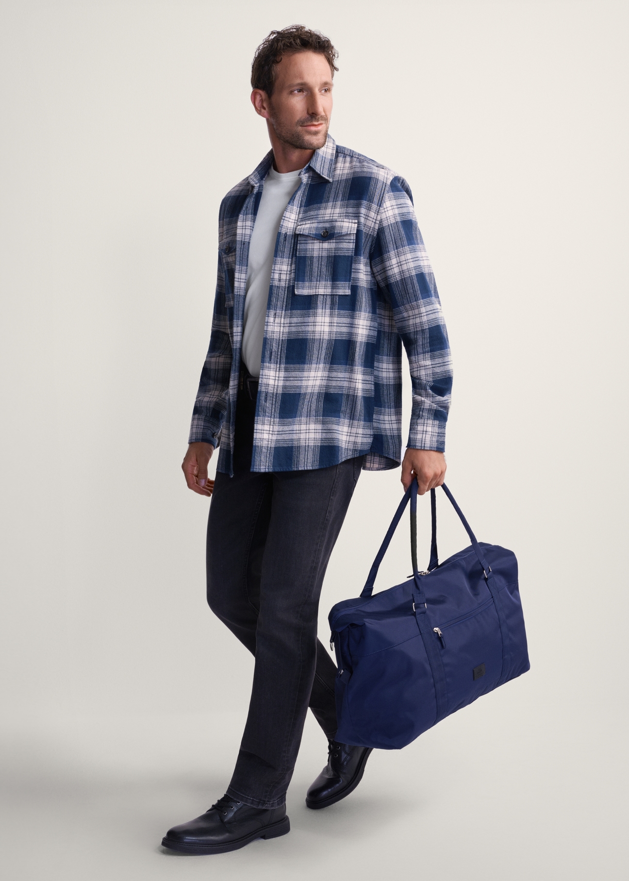 Navy blue TORMN-0382-69 travel bag (Z25), product view in model's hand. Full body visible.