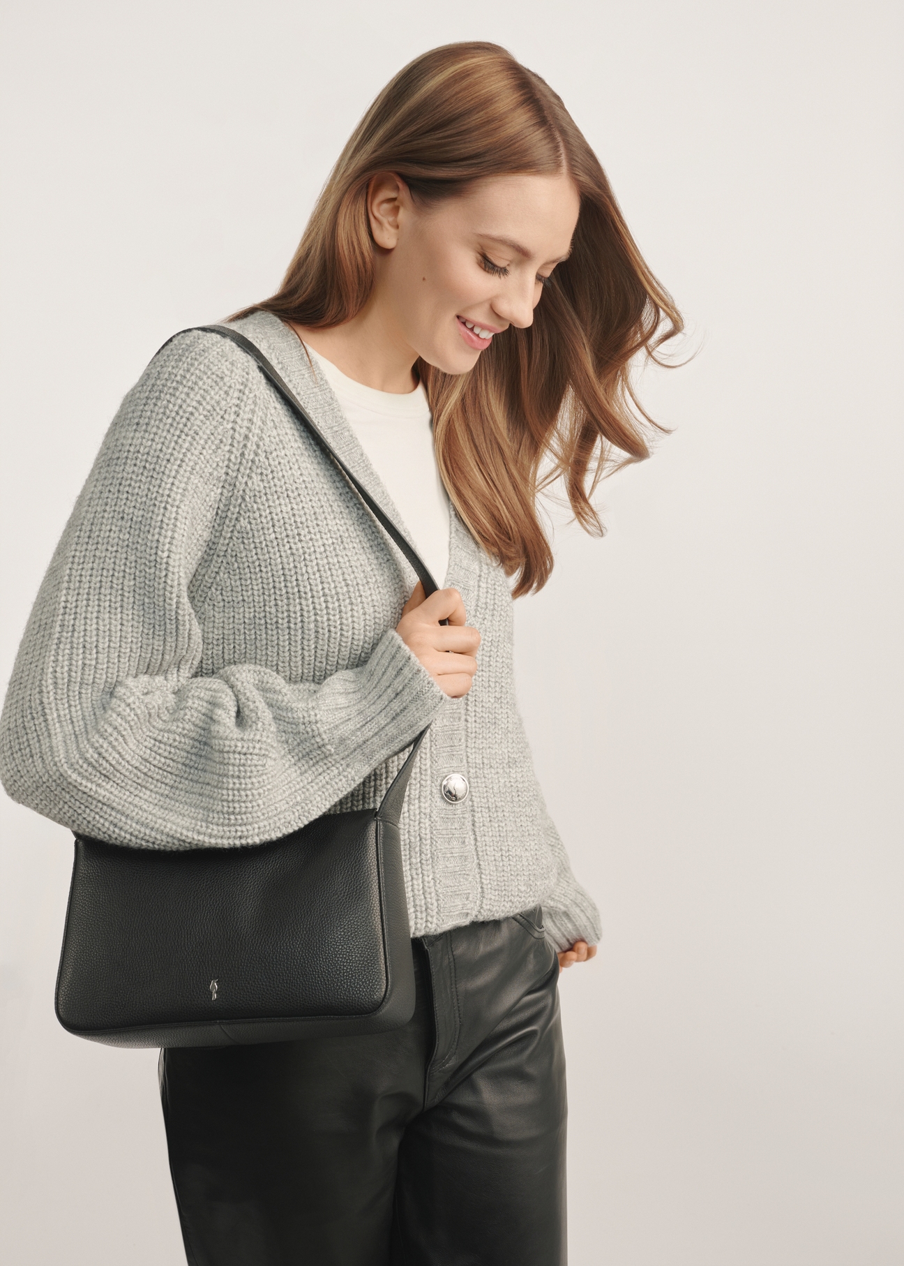 Women's black leather messenger bag TORES-1199-99(Z25) - front view of the product on a model against a white background. Half of the silhouette visible.
