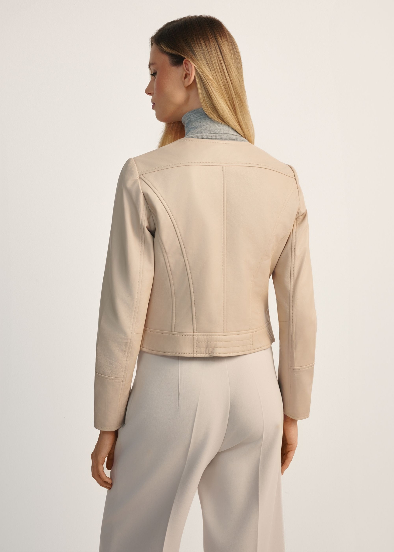 Women's beige leather biker jacket KURDS-0273-1B(KS) -  product view from the back on the model, half of the silhouette visible.