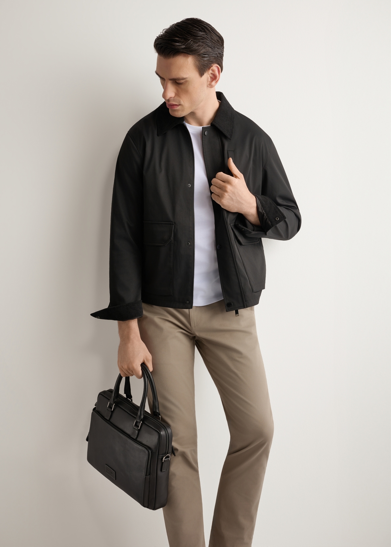 Black leather men's bag TORMS-0524-99(Z26), diagonal view of the product on the model. Half of the silhouette visible.