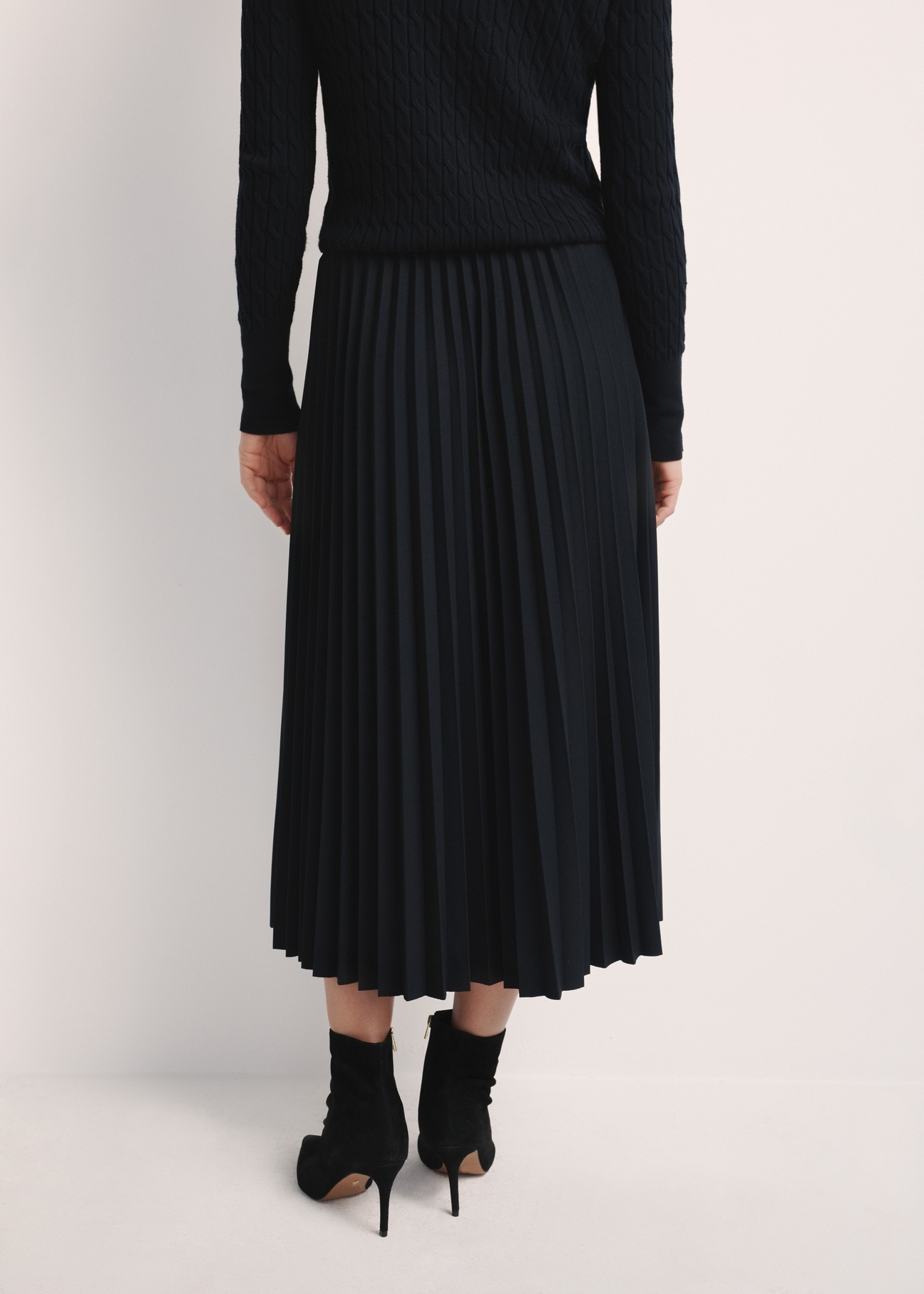 Black pleated women's dress SPCDT-0096-99(Z25), product visible from the back on the model, half of the silhouette visible.