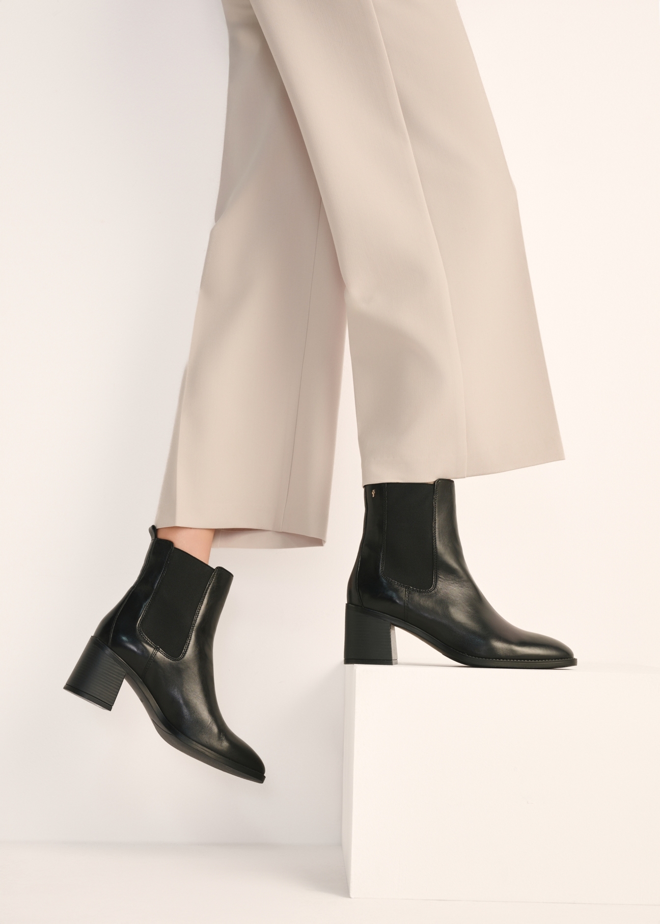 Women's black leather high-heeled Chelsea boots BUTYD-1185-99(Z25) - front view of the product on a model against a white background. Half of the silhouette visible.