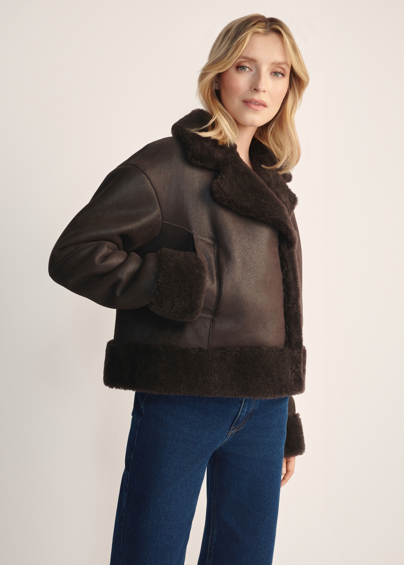 Women's brown leather sheepskin coat KOZDS-0096-3099(Z25) - side view, on a model, against a white background. Knee-length silhouette visible.