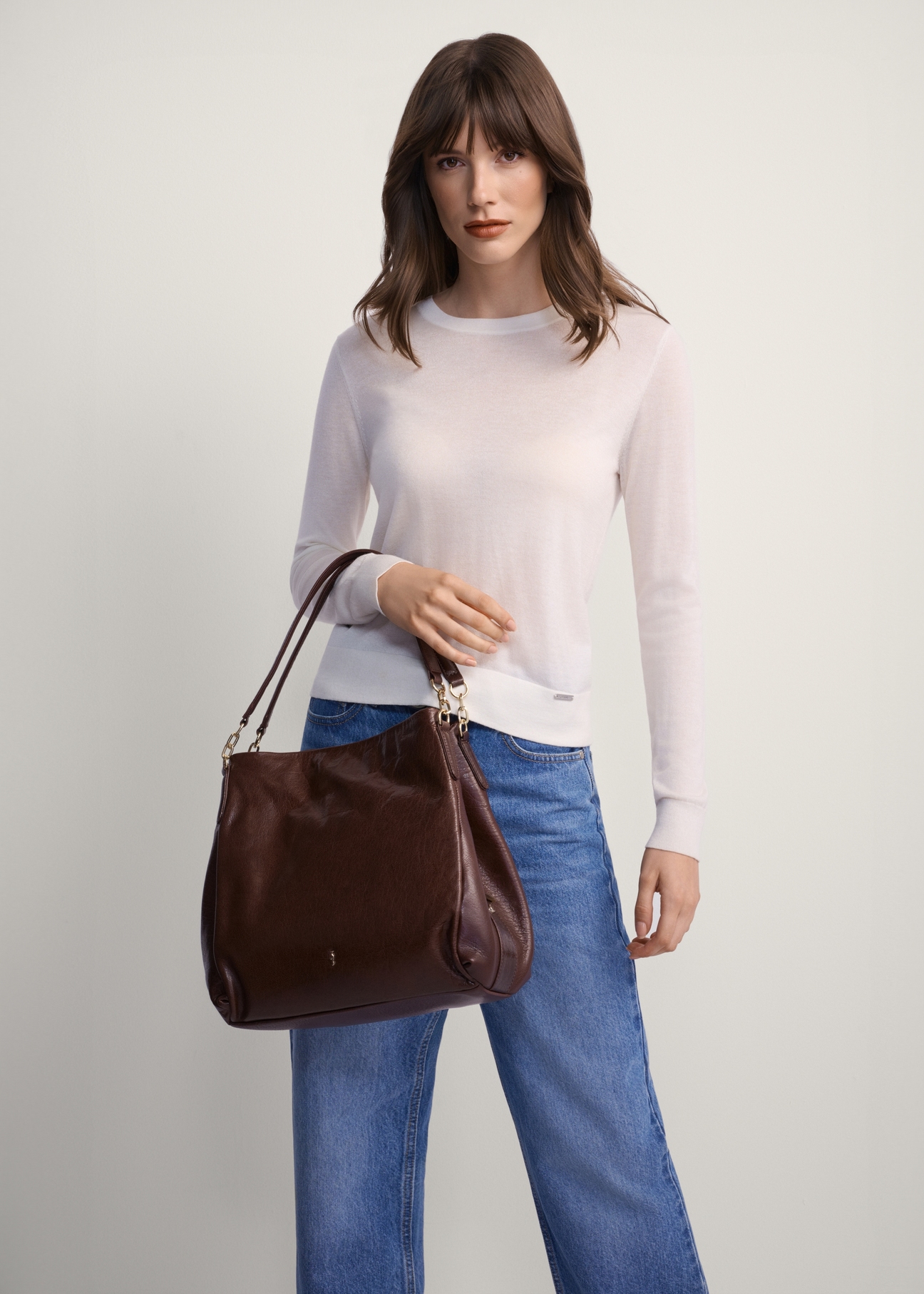 Brown leather women's shopper bag TORES-0636D-89(Z25), front view of the product on a model, half of the silhouette visible.