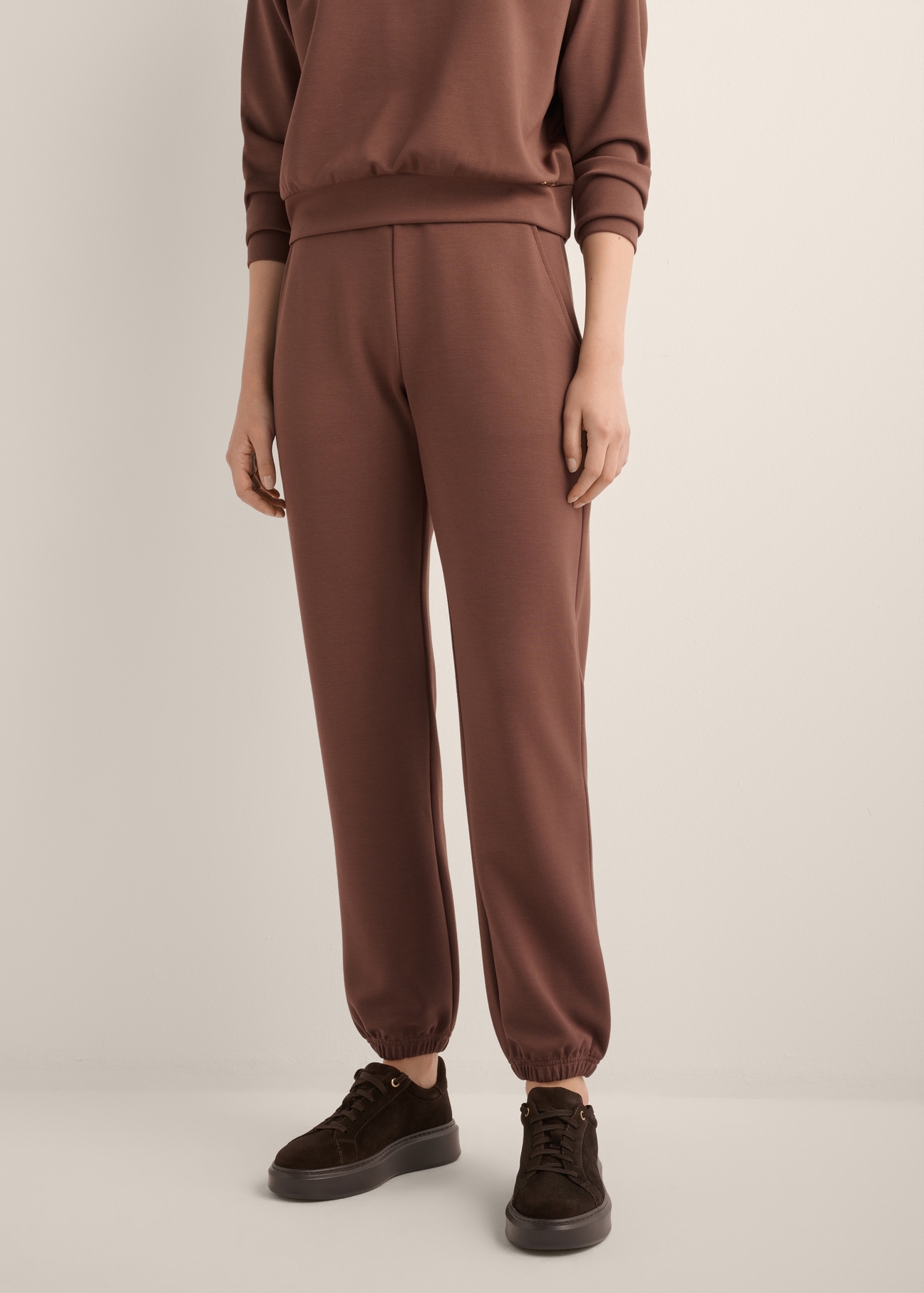 Brown women's trousers SPODT-0117-1H(Z26), front view of the product on the model. Half of the silhouette visible.