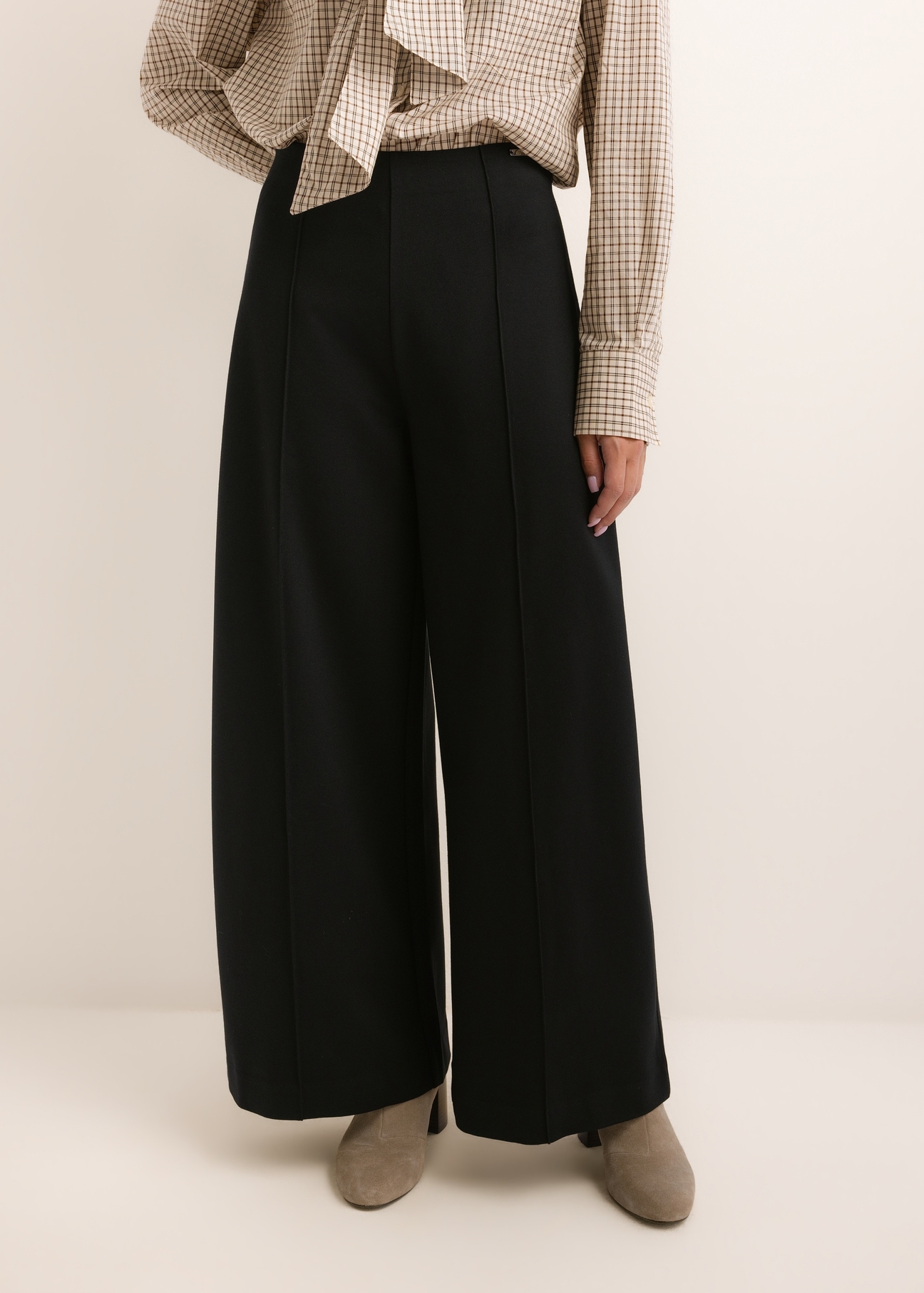 Black women's wide leg trousers SPODT-0130-99(Z26), front view of the product on the model. Half of the silhouette visible.