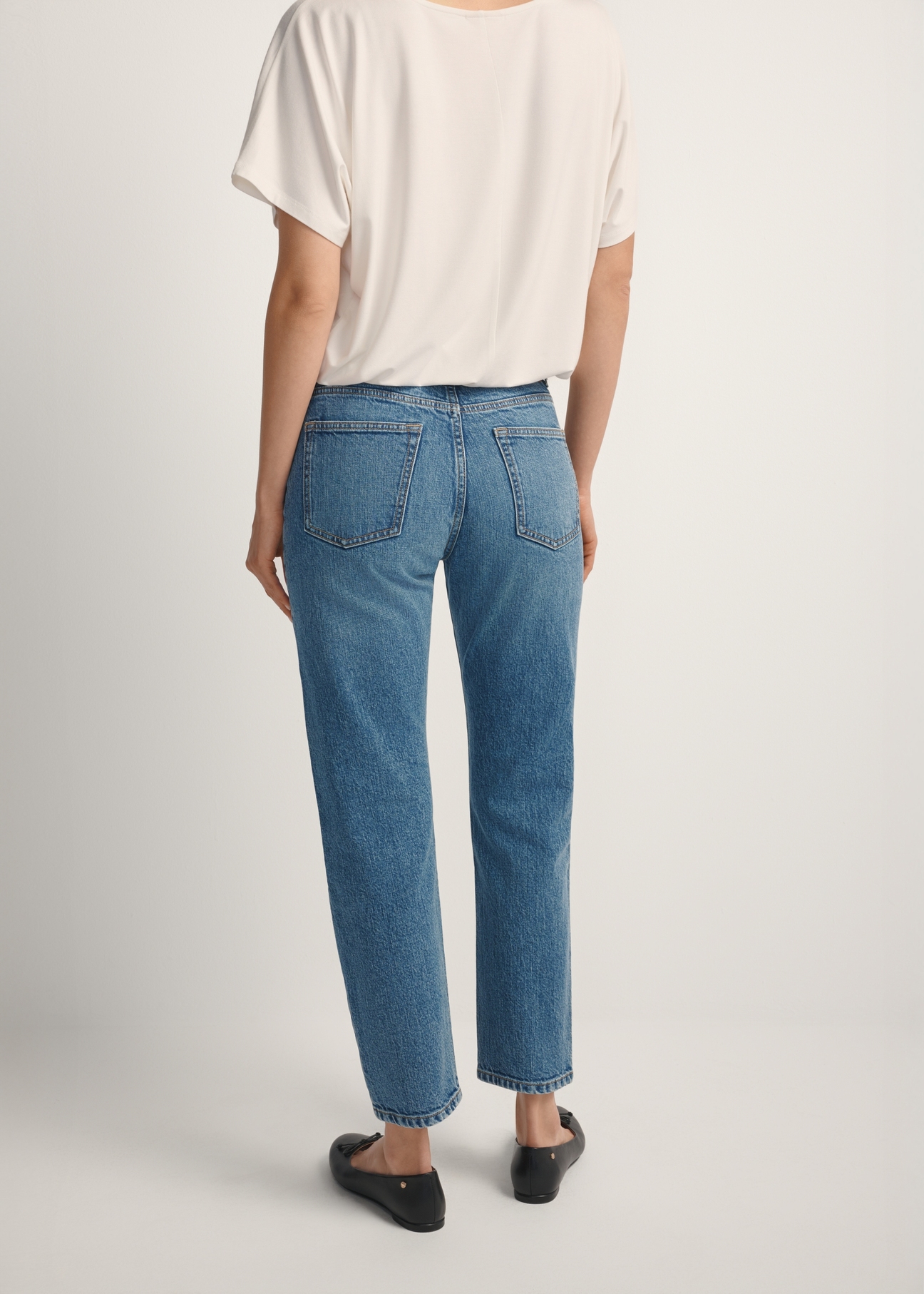 Women's dark blue denim jeans JEADT-0011-7C(W26), back view of the product on the model. Half of the silhouette visible.