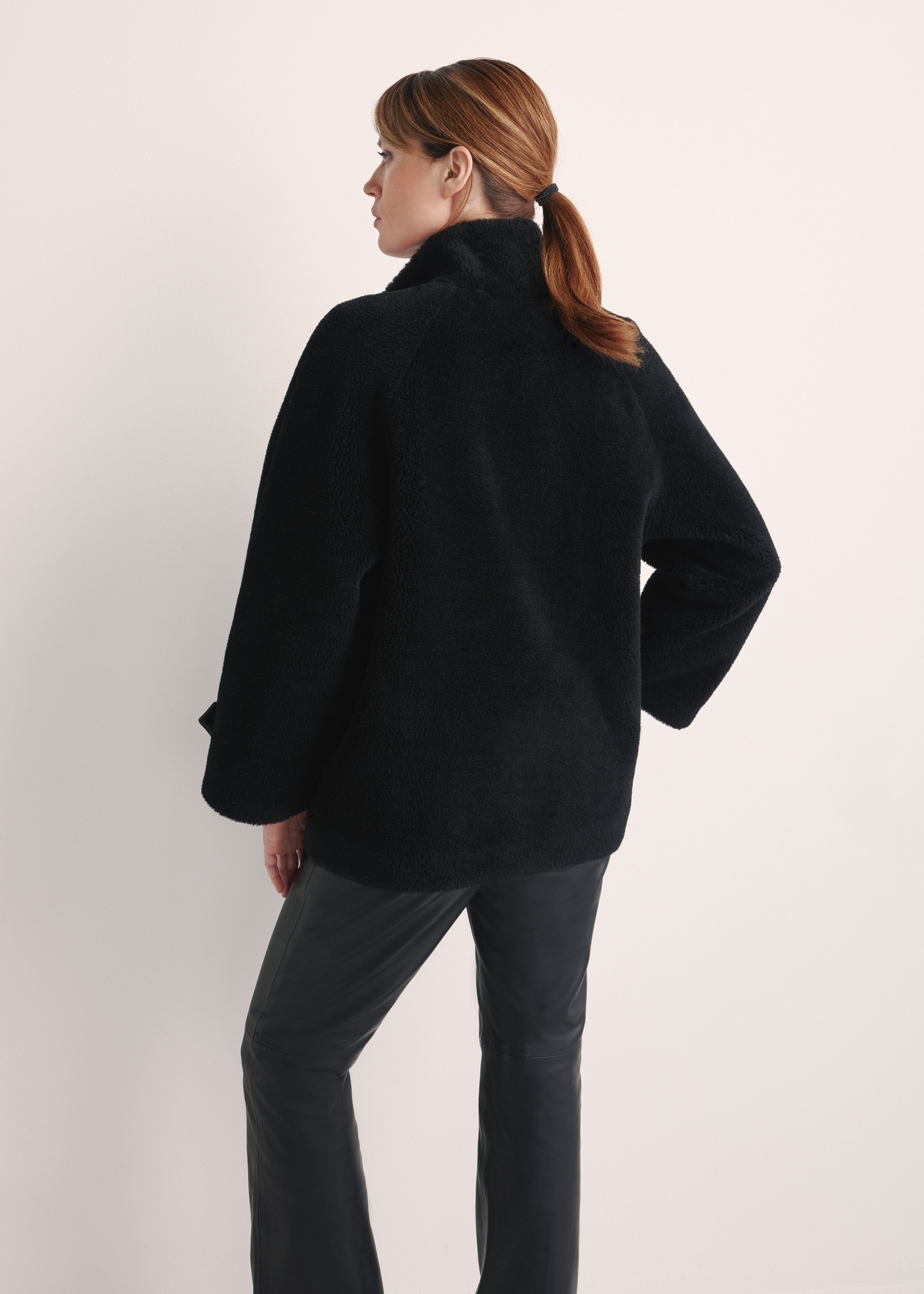 Women's wool fur coat in black FUTDW-0032-99(Z25) - product view from the back on a model on a white background. Half of the silhouette visible.
