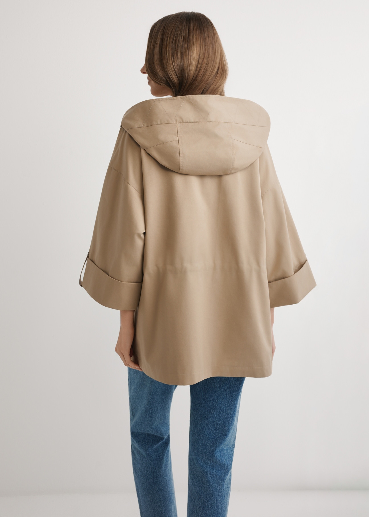 Beige women's transitional jacket KURDT-0661-1B(W26) - back view of the product, on a model, against a light background. Knee-length silhouette visible.