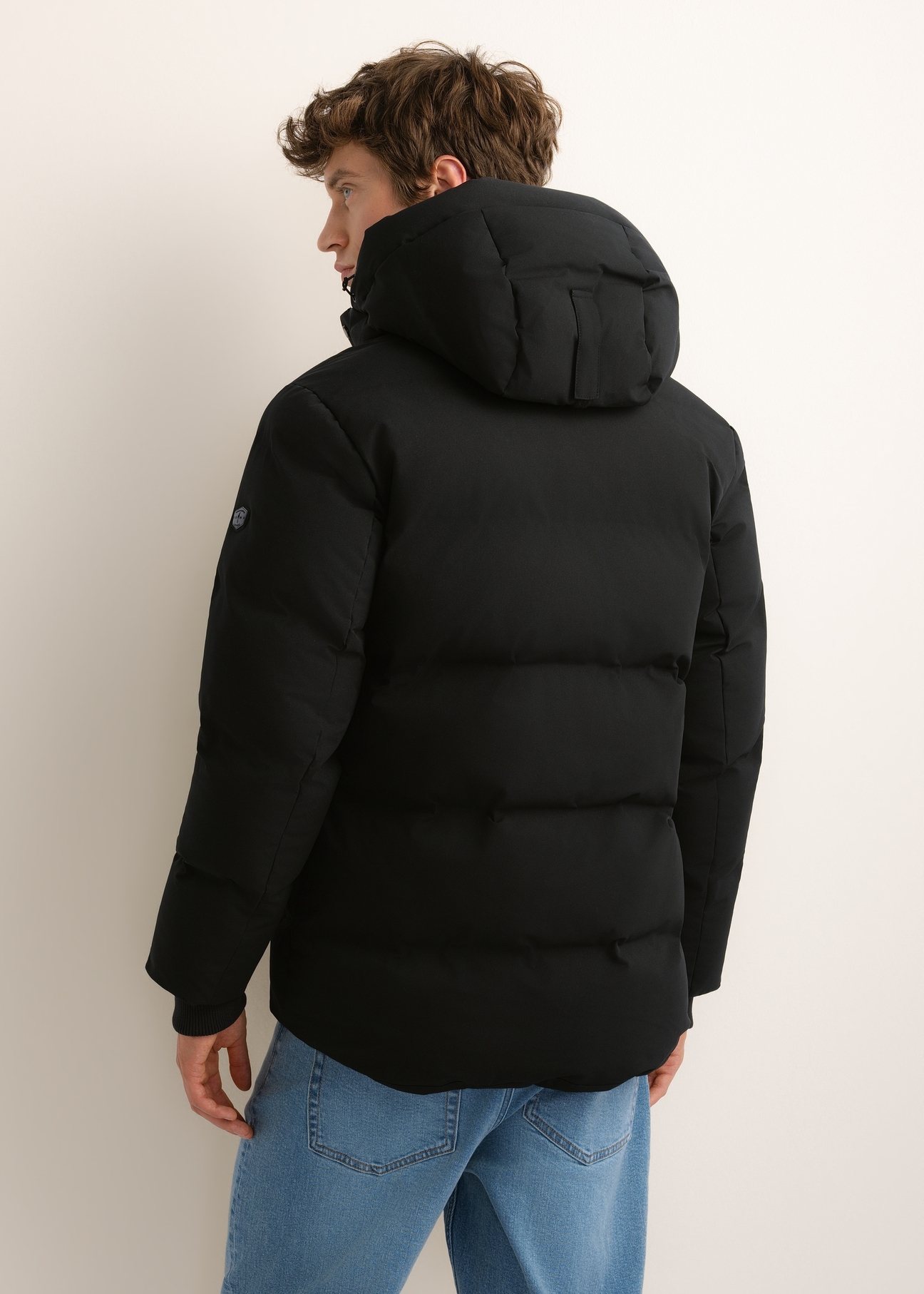 Men's black winter jacket KURMT-0447-99(Z26), rear view on a model. Half of the figure is visible.