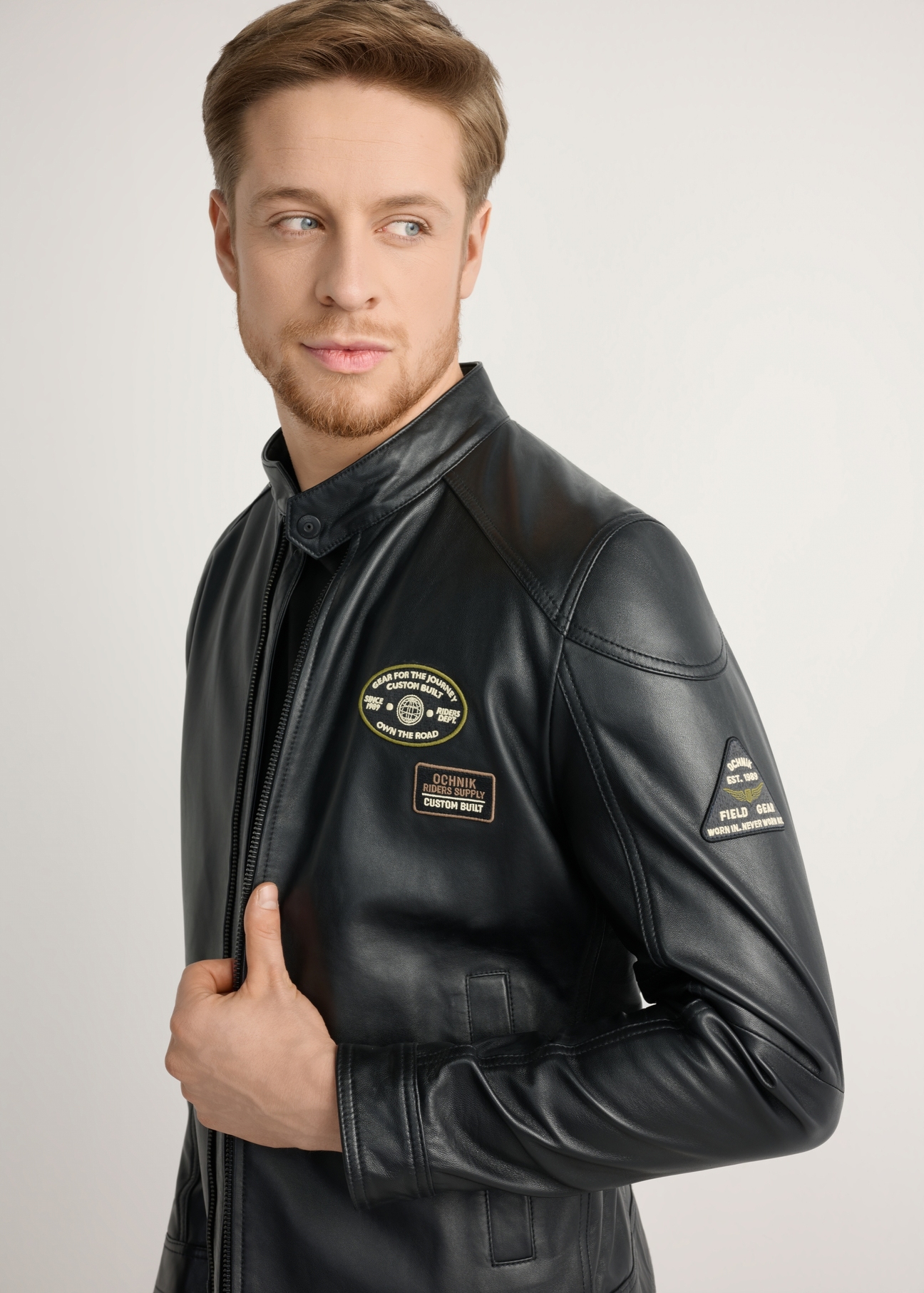 Men's black leather jacket KURMS-0301A-99(W26) - side view of the product, on a model, against a light background. Half of the silhouette visible.