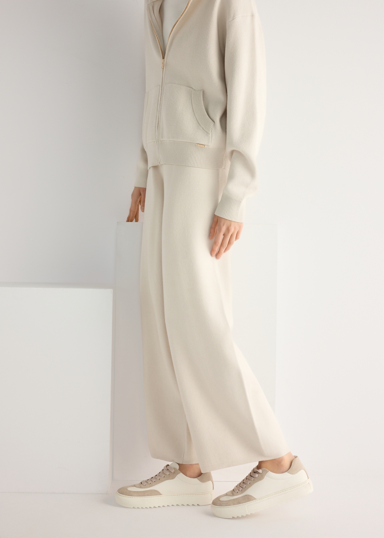 Women's leather sneakers in cream color BUTYD-1260-0B(W26), product view from the side on the model, half of the silhouette visible.