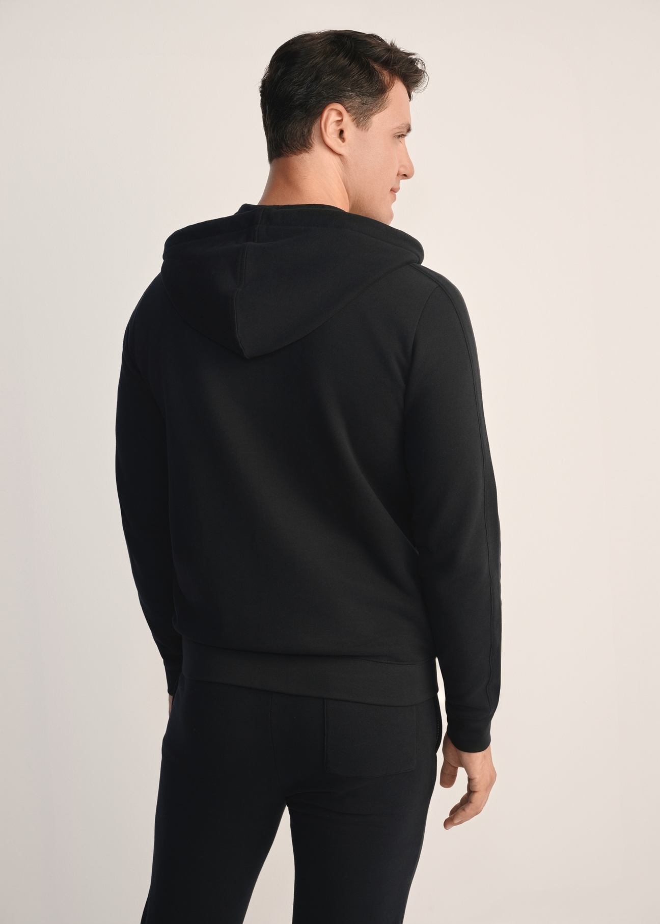 Men's black hoodie BLZMT-0074-99(Z25), back view of the product on the model. Half of the silhouette visible.