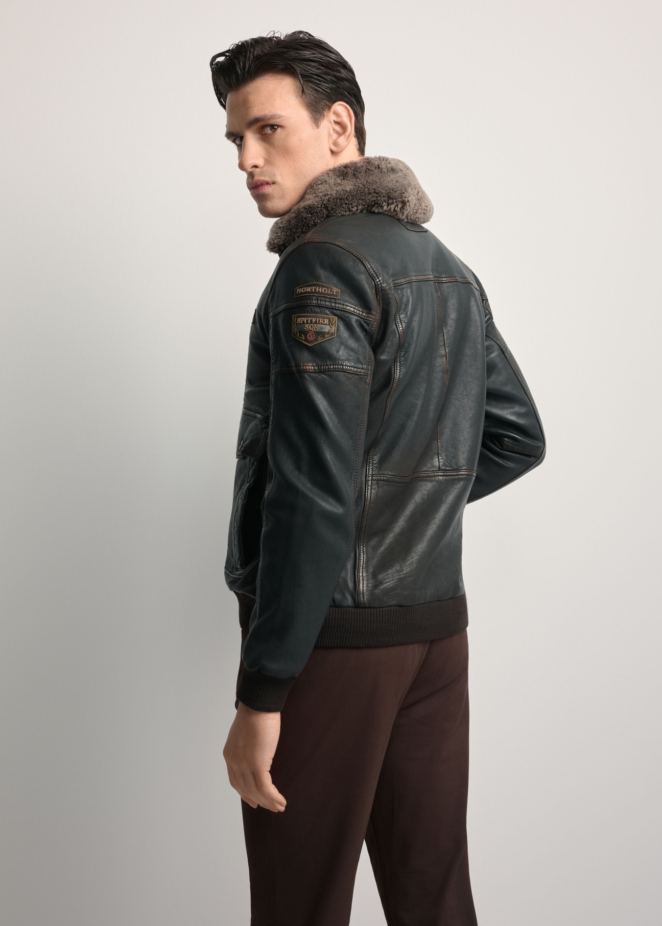 Brown leather jacket with collar KURMS-0380-1I(Z26), product view from the back on the model. Half of the silhouette visible.
