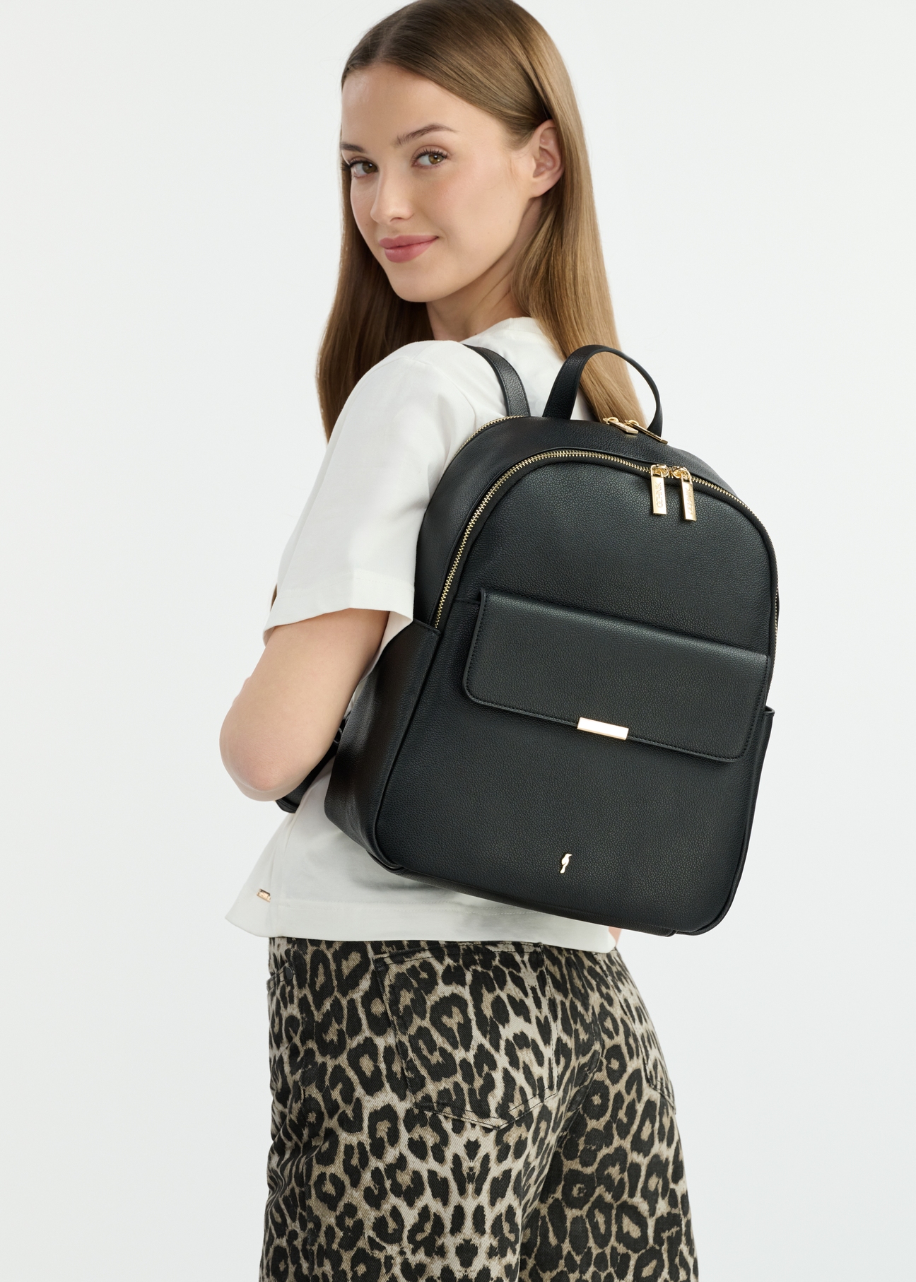 Black women's backpack TOREC-1034-99(W25), front view of the product on a model. Half of the silhouette visible.