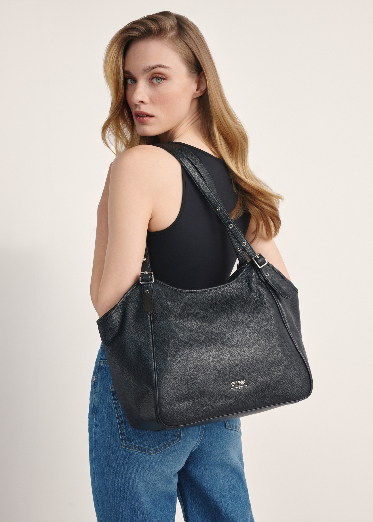 Large black leather women's handbag TORES-1042D-99(Z25) - front view of the product on a model against a white background. Half of the back is visible.